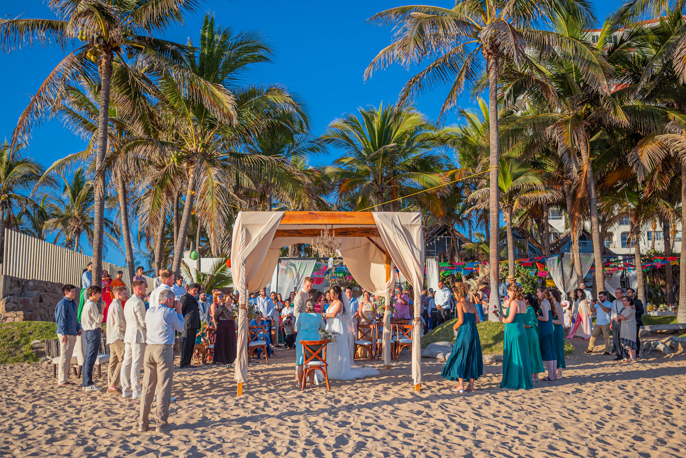 Cost-saving tips for destination weddings — A bride holds a colorful tropical bouquet against an ocean backdrop.