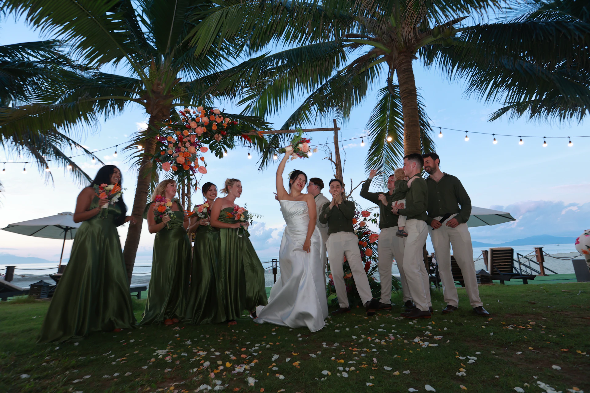 Bride throws bouquet at outdoor wedding with palm trees