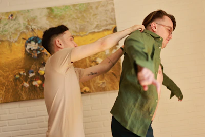 Man adjusting another man's shirt collar