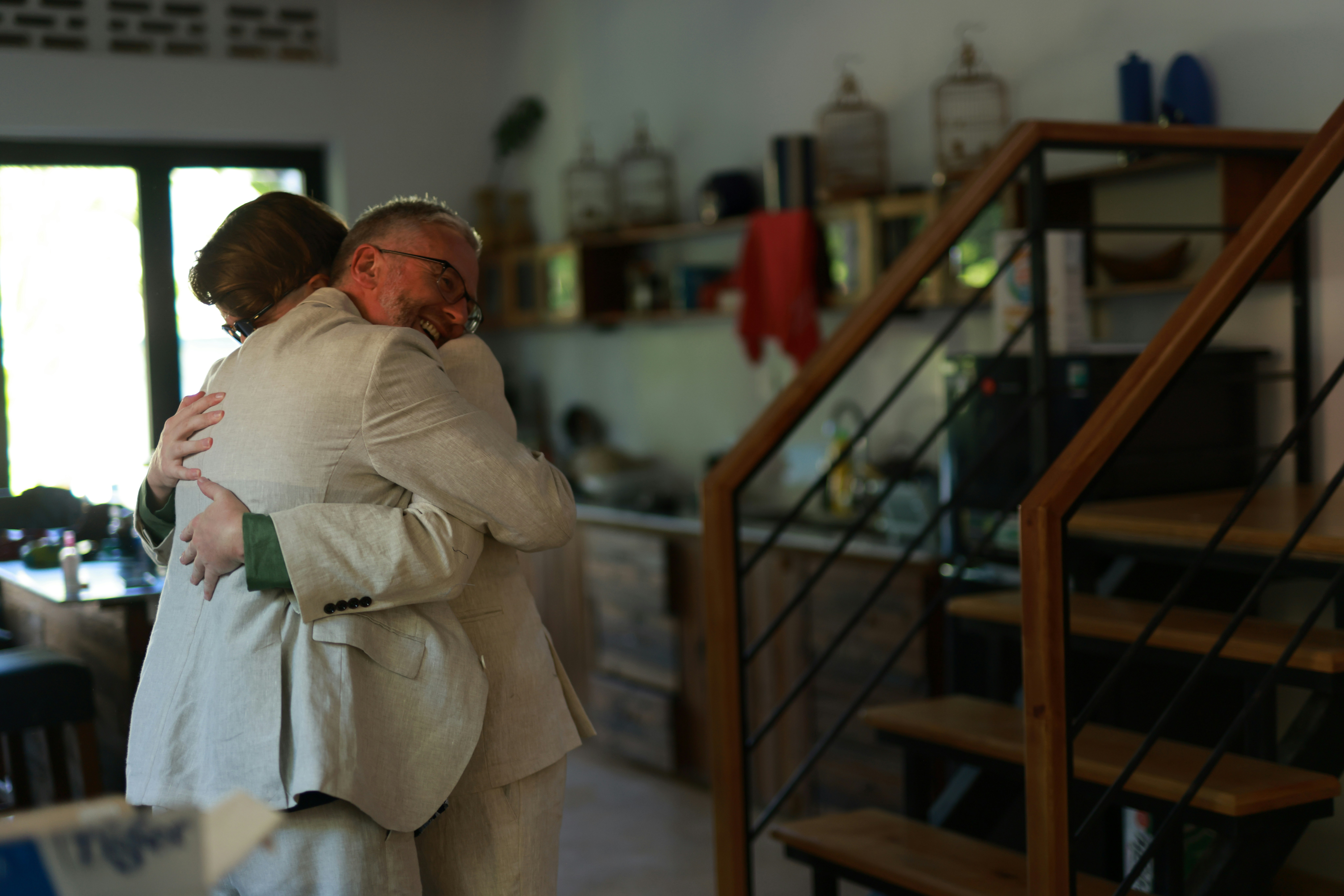 Two people embracing warmly indoors.