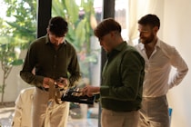 Three men in formal attire gathered indoors.