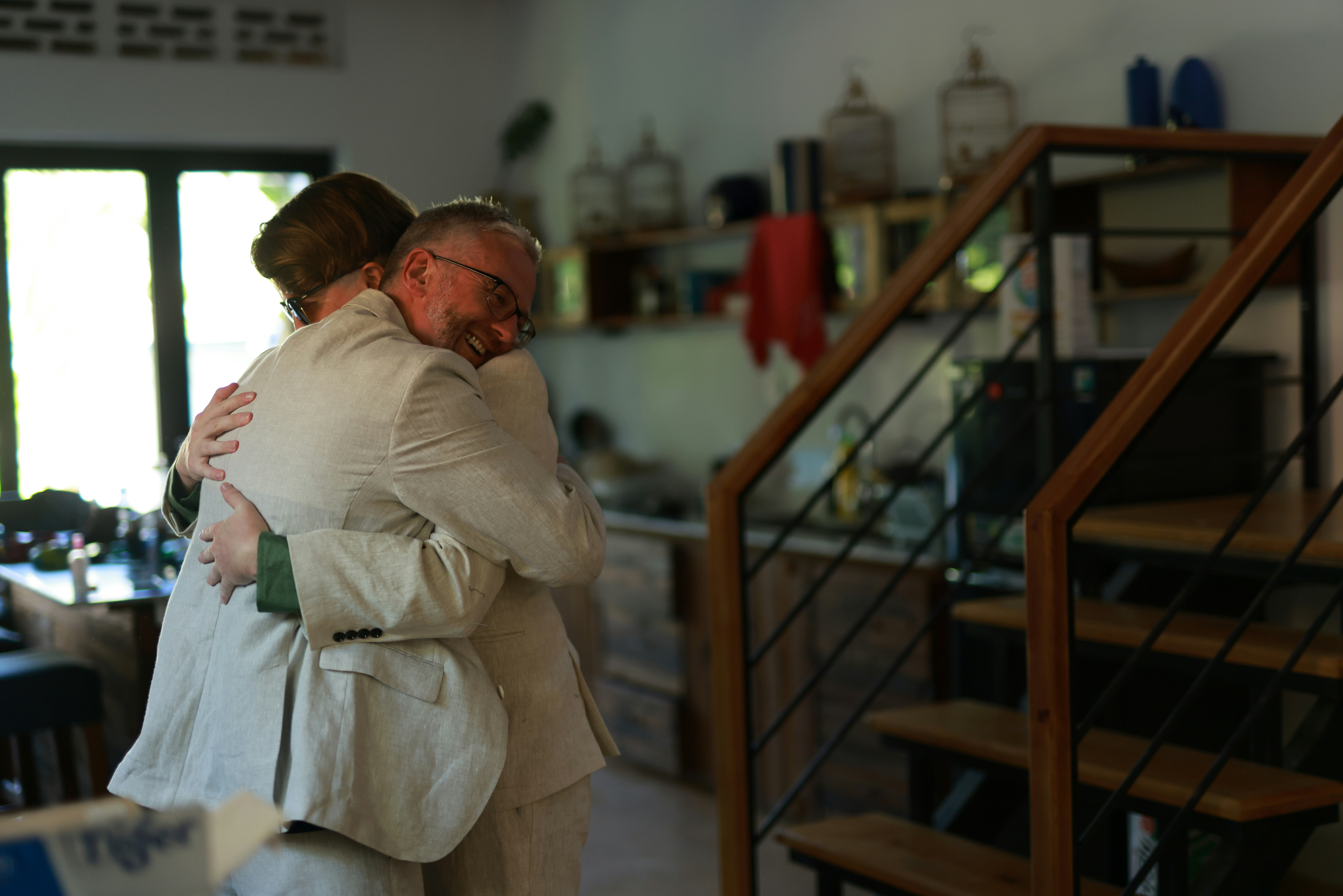 Zwei Menschen, die sich drinnen herzlich umarmen.