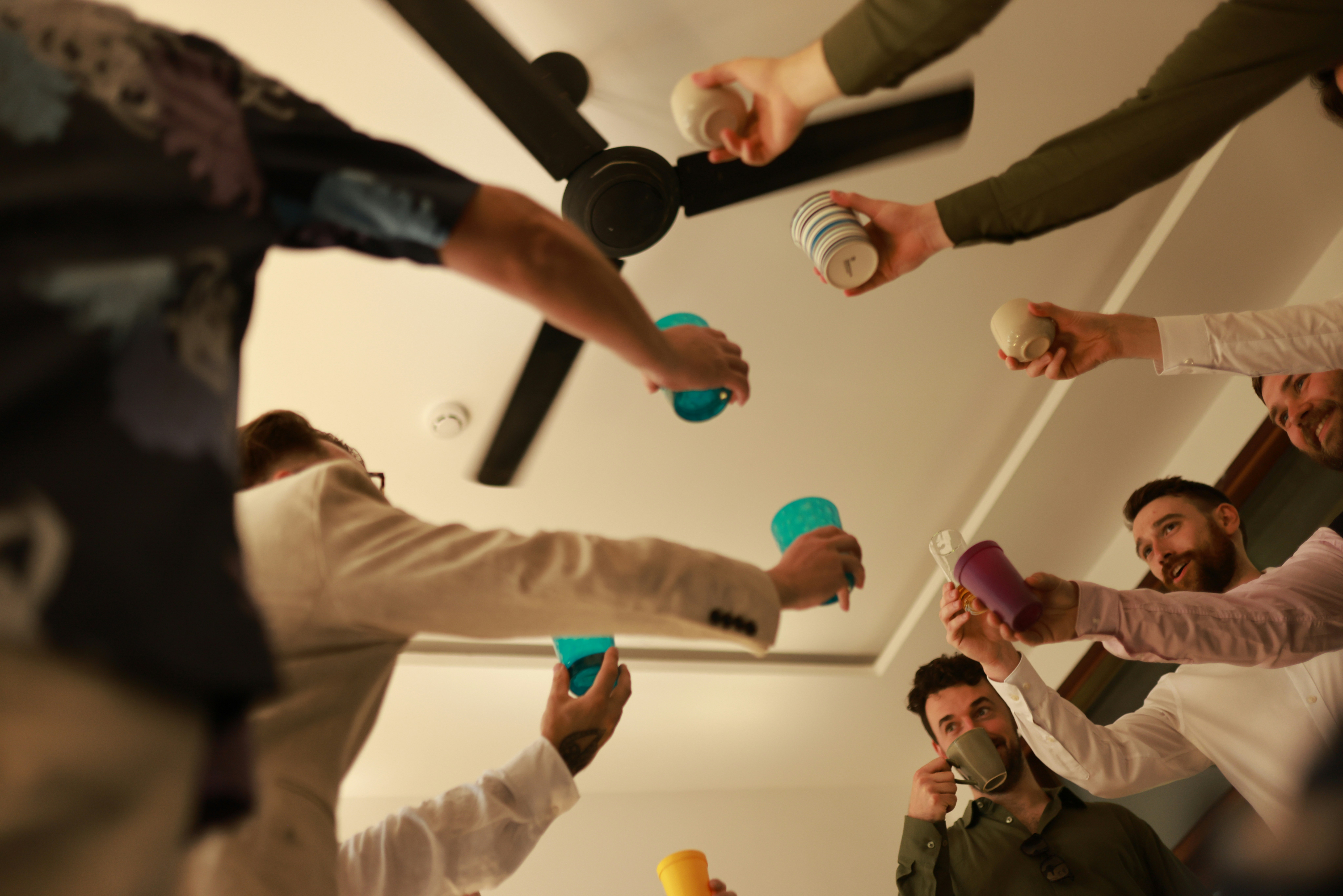 Group of men toasting drinks overhead