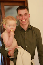Man holding a baby with red hair