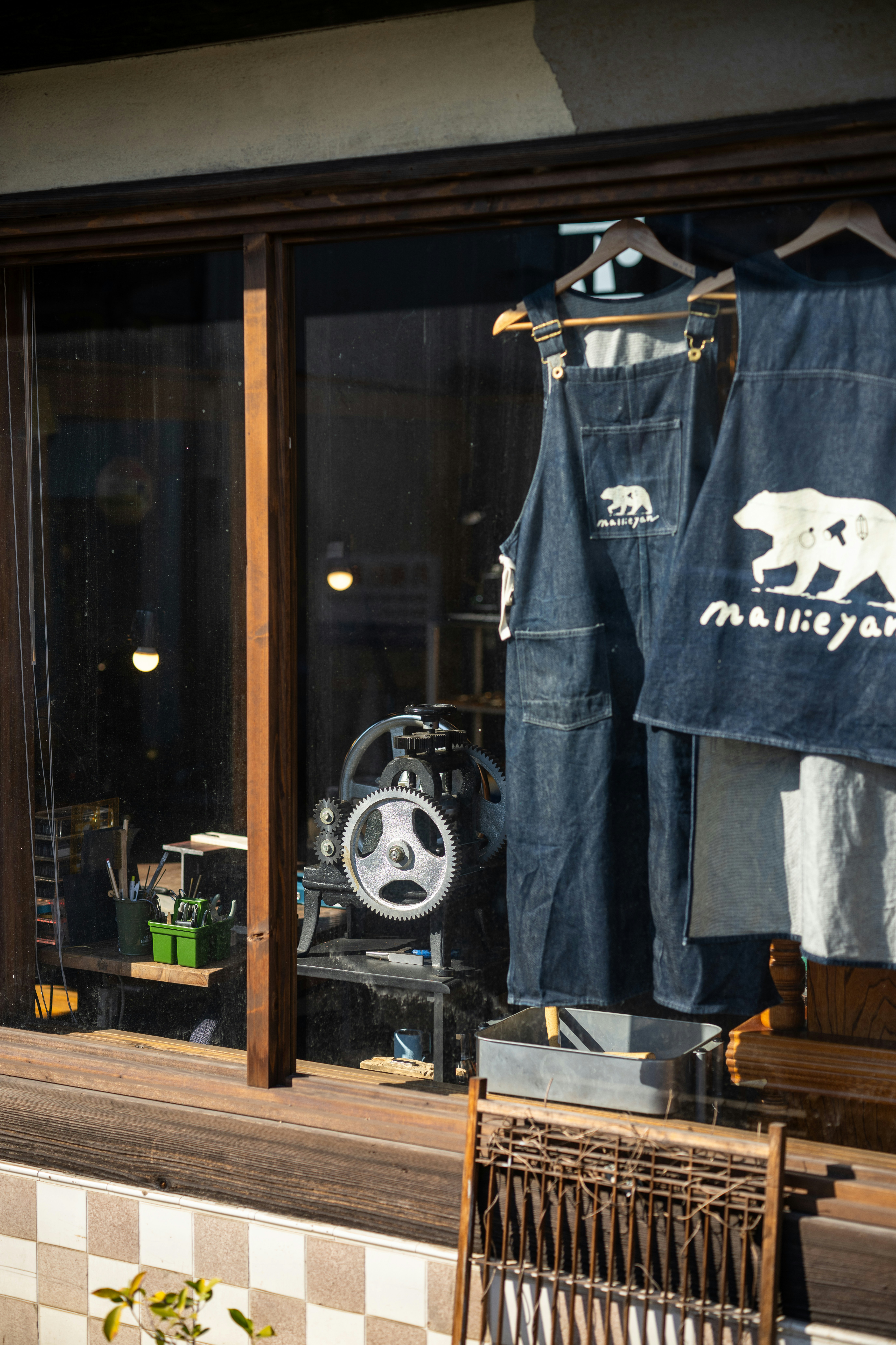 デニムのオーバーオールで、店のウィンドウにベアのロゴが飾られています。