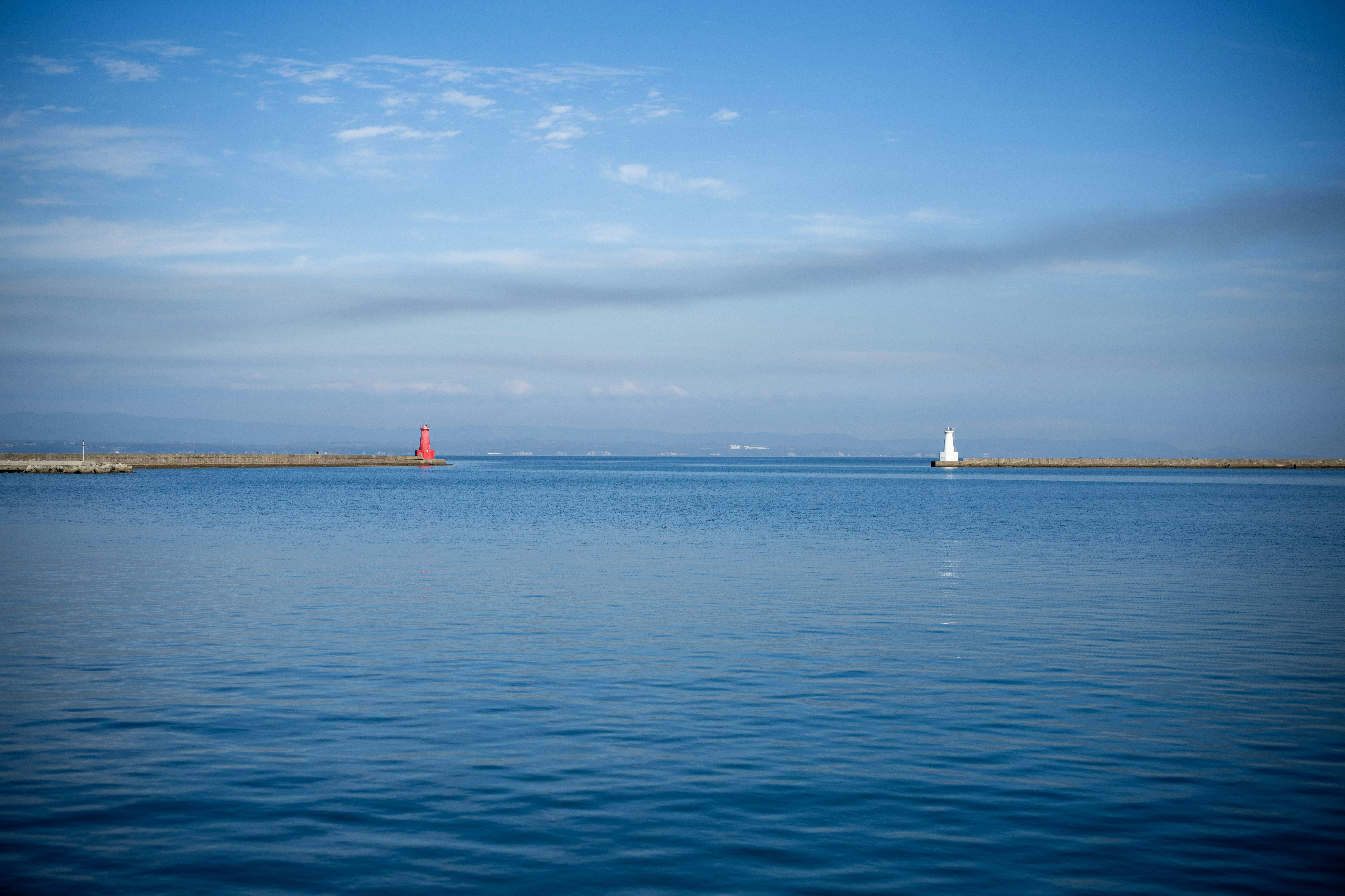 Two lighthouses mark the entrance to a harbor