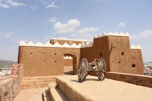 Ancient mud-brick fortress with a cannon on rampart.