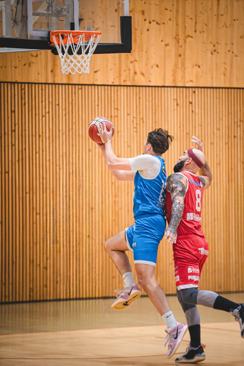 Basketball players competing for the ball near the hoop