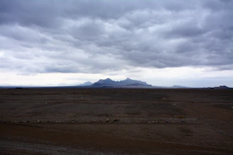 Dark clouds over a desolate mountain landscape.