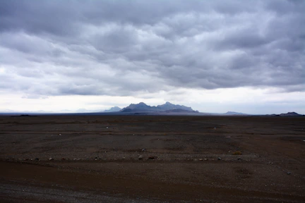 Dark clouds over a desolate mountain landscape.