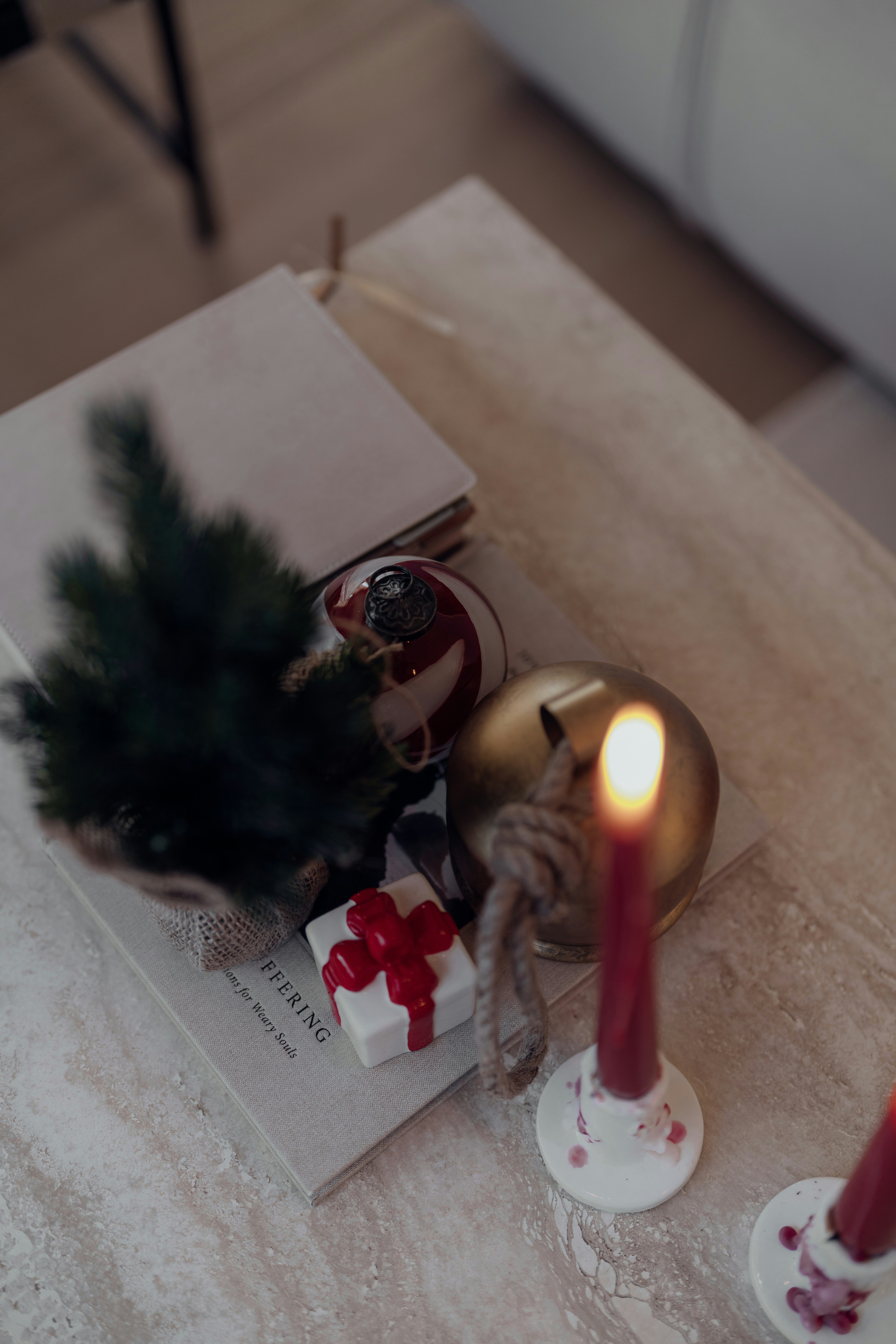 Decorações de Natal em uma mesa com uma vela acesa.