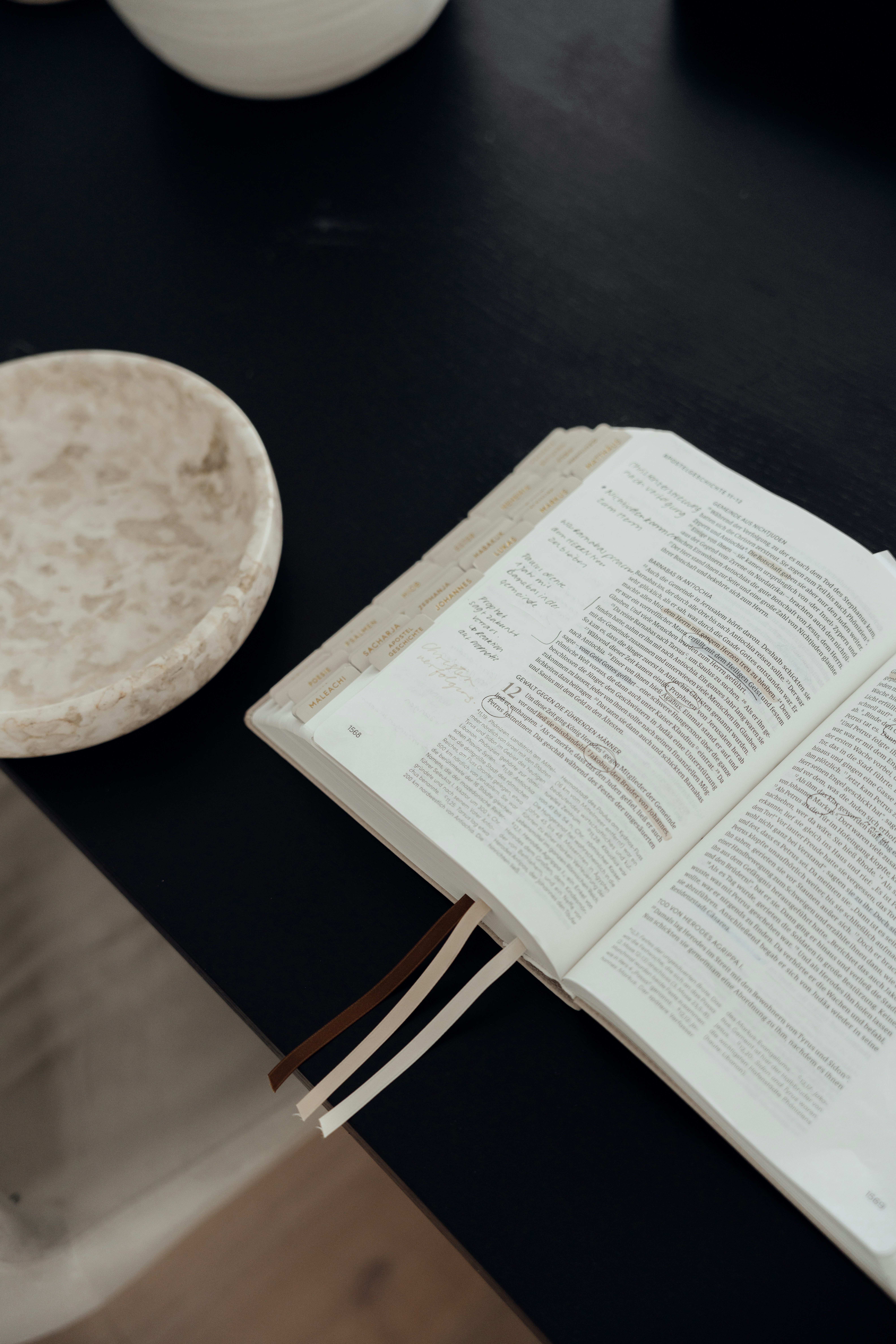 Open book with bookmarks on a dark surface