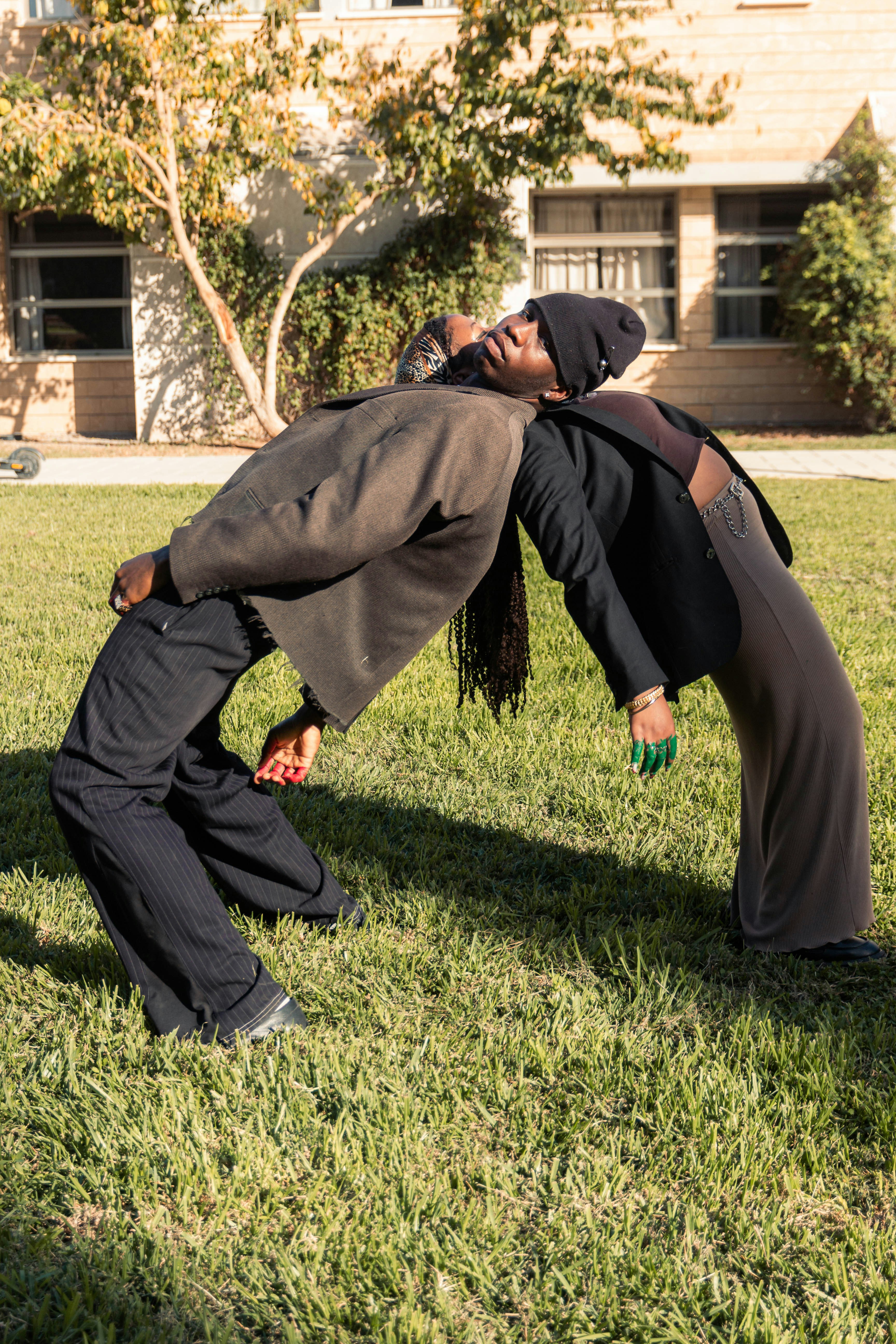 Two people arching their backs in a park.