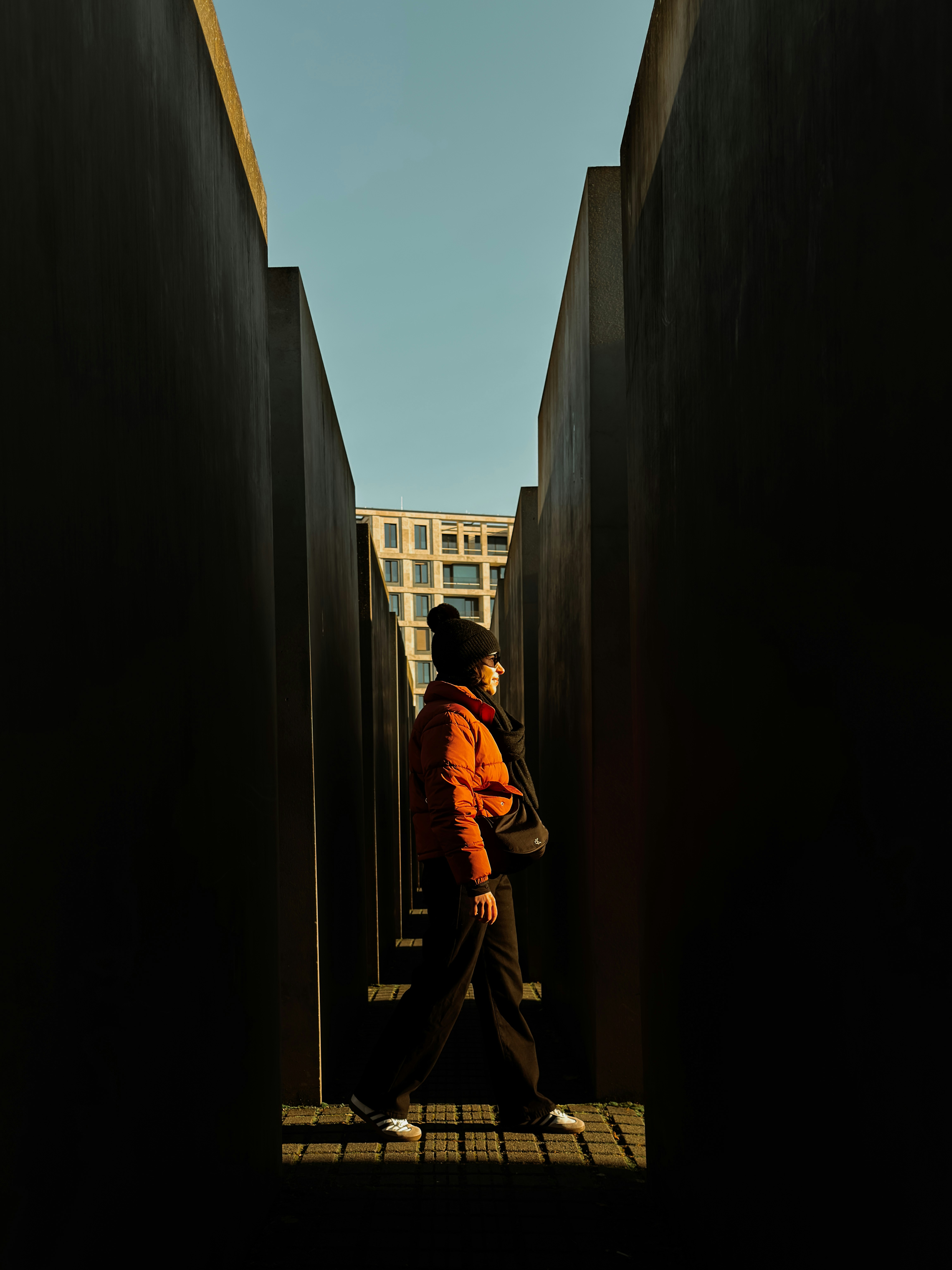 Woman walks through dark concrete memorial structures