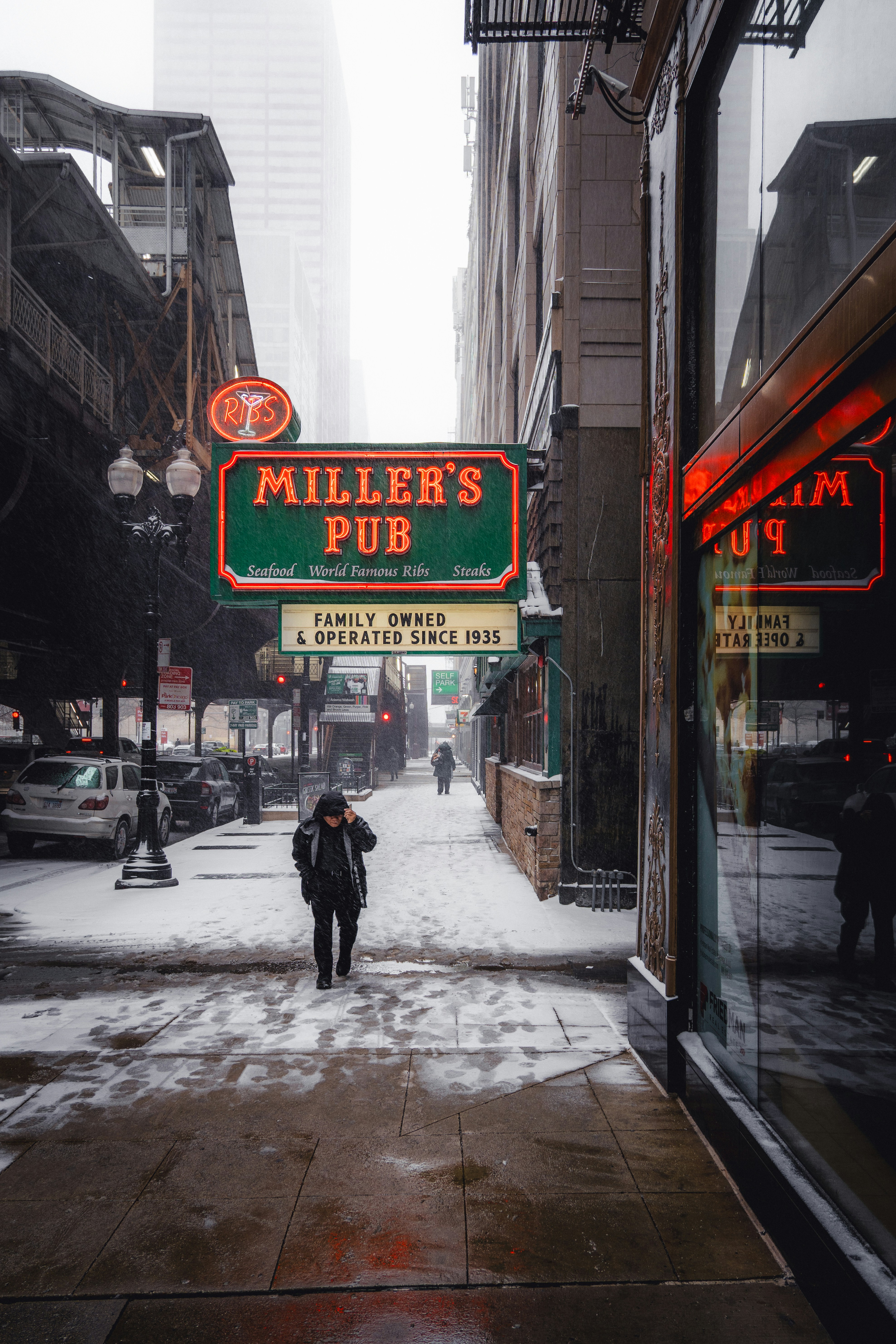 A snowy street scene with miller's pub sign.