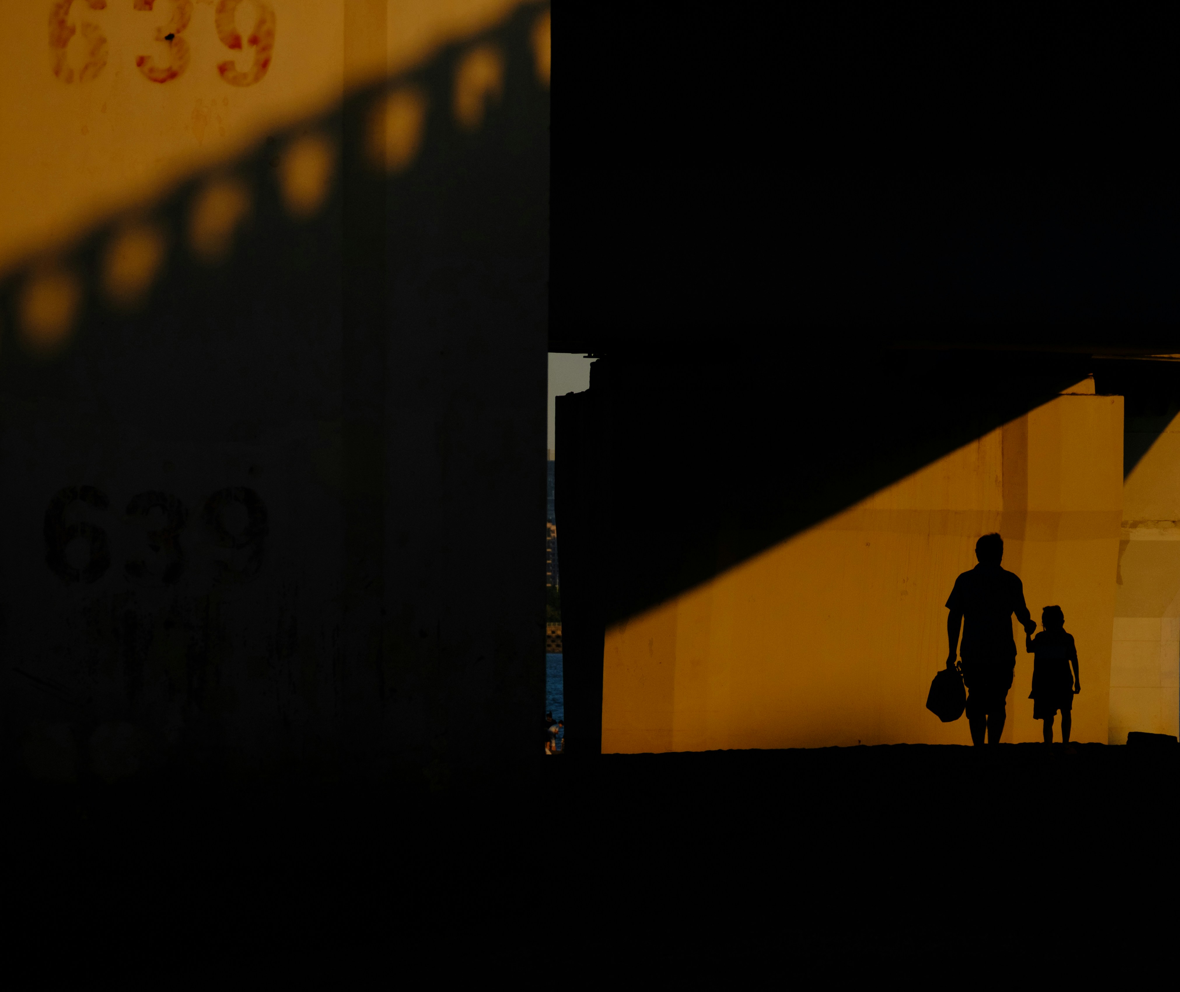 Silhouettes of a parent and child walking together