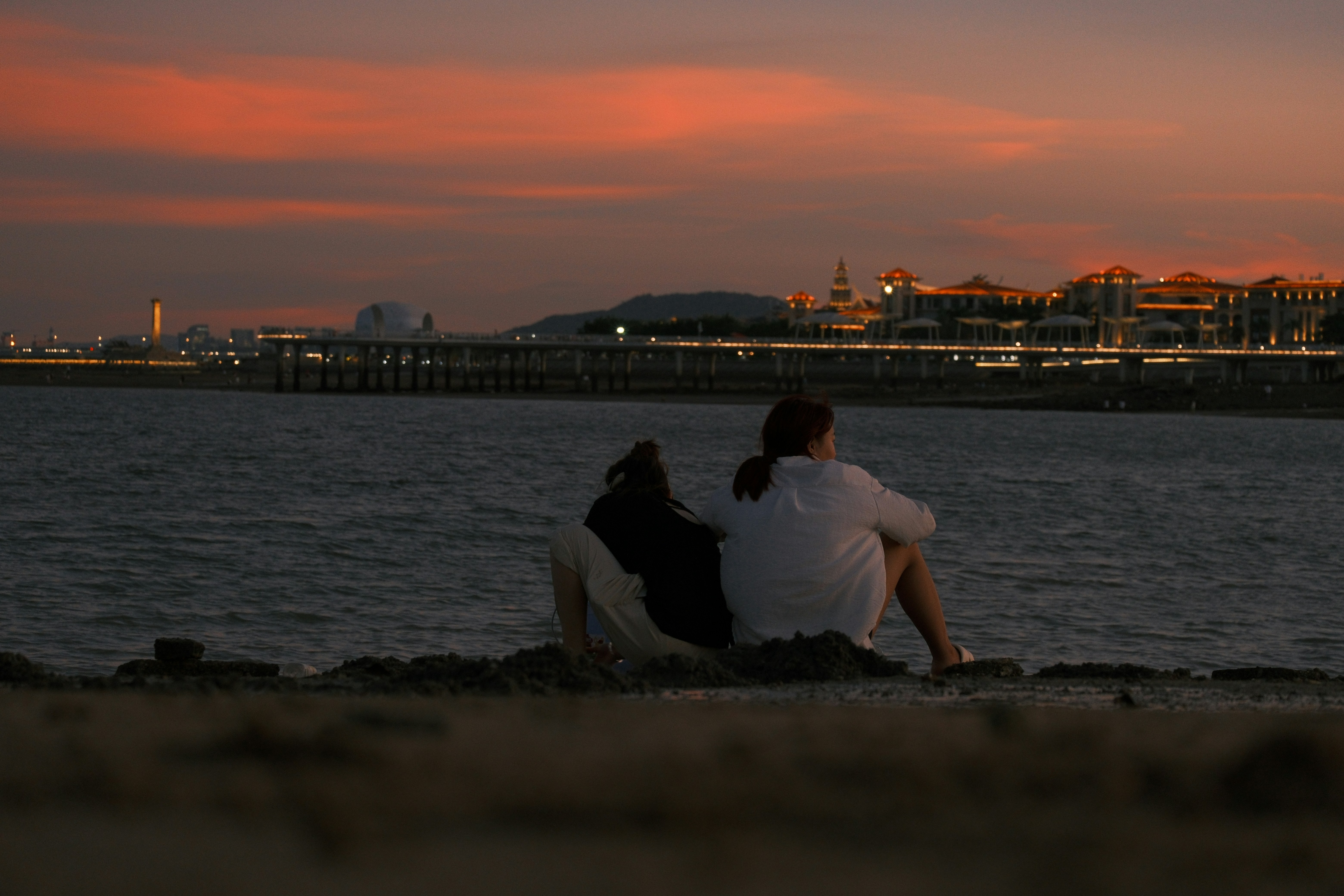 Pareja viendo la puesta de sol sobre el horizonte de la ciudad