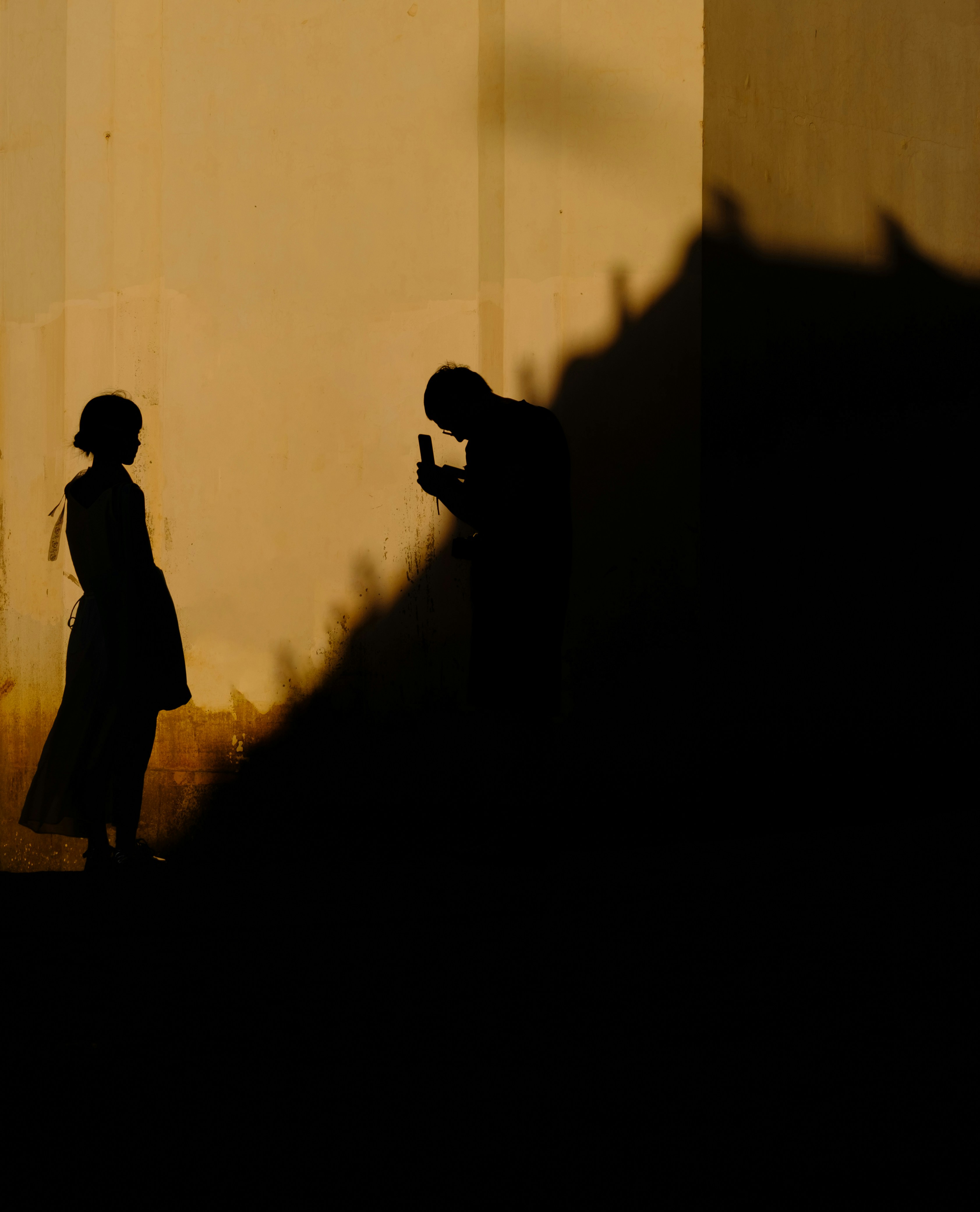 Silhouettes of two people against a wall
