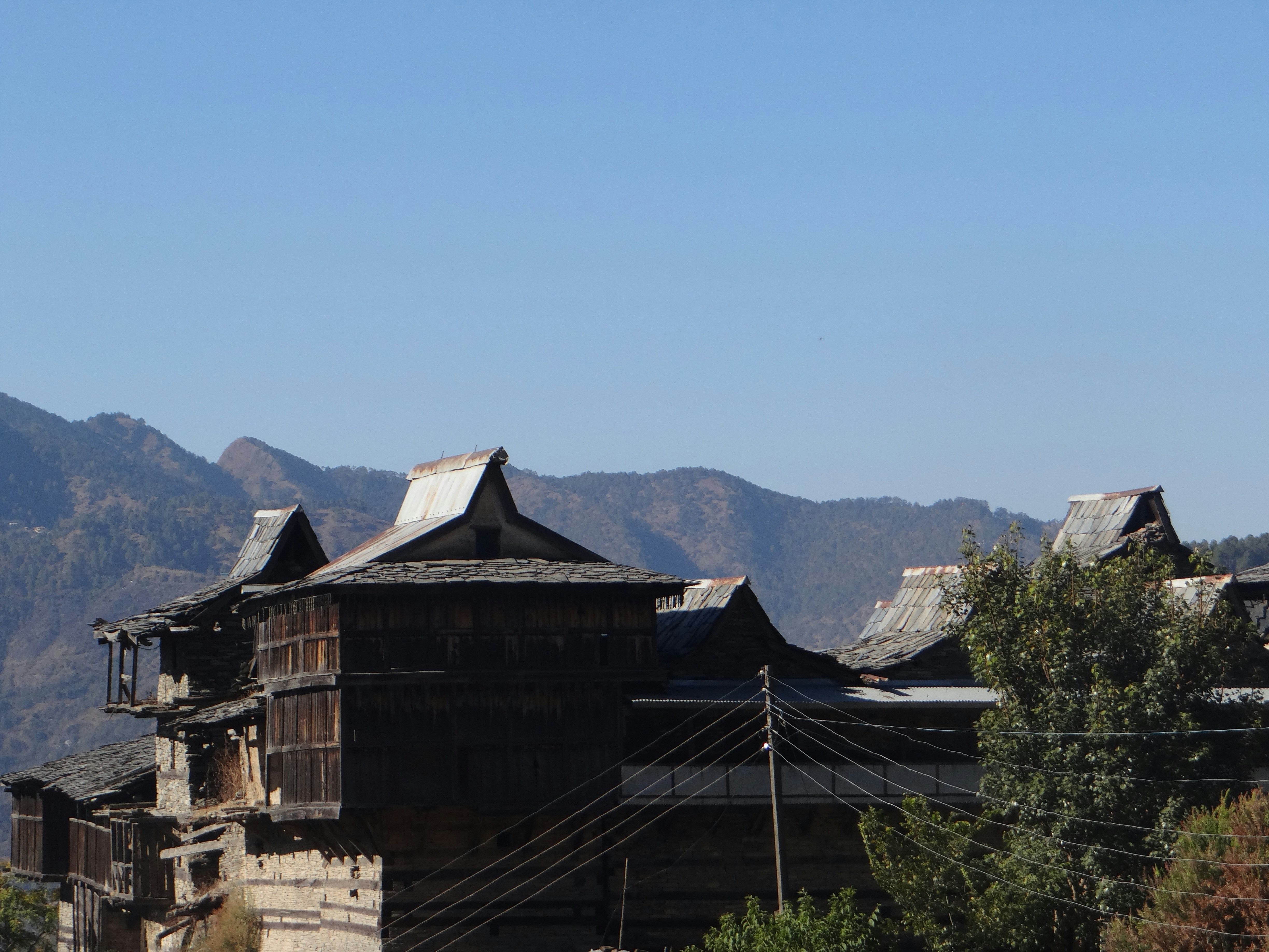 Traditional wooden houses on a hillside under blue sky