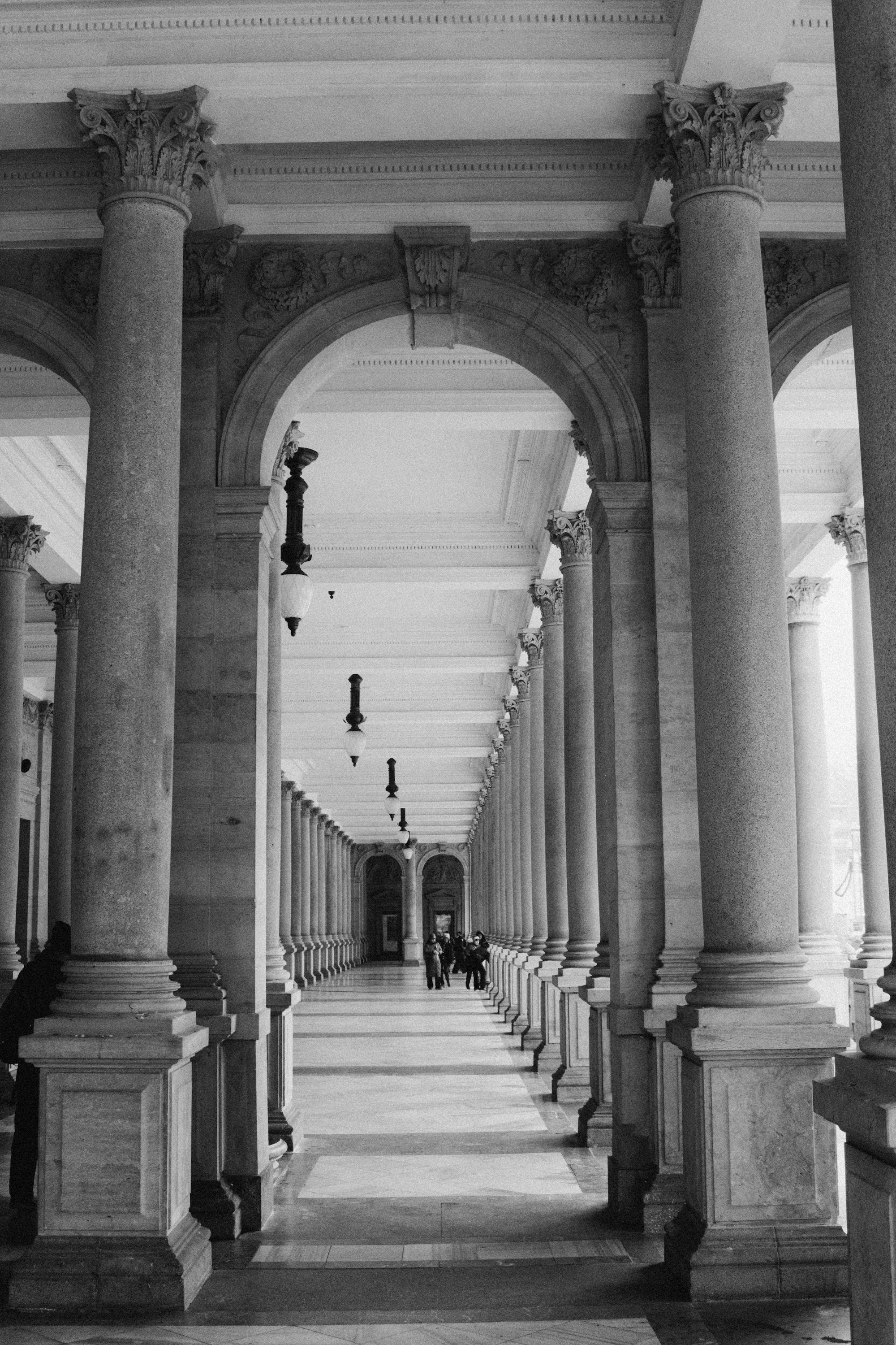 A grand colonnade in black and white, identical columns receding until they merge in the distance