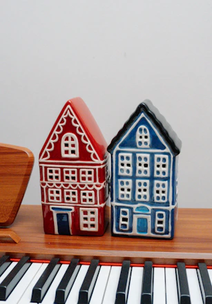 Two decorative houses on a piano
