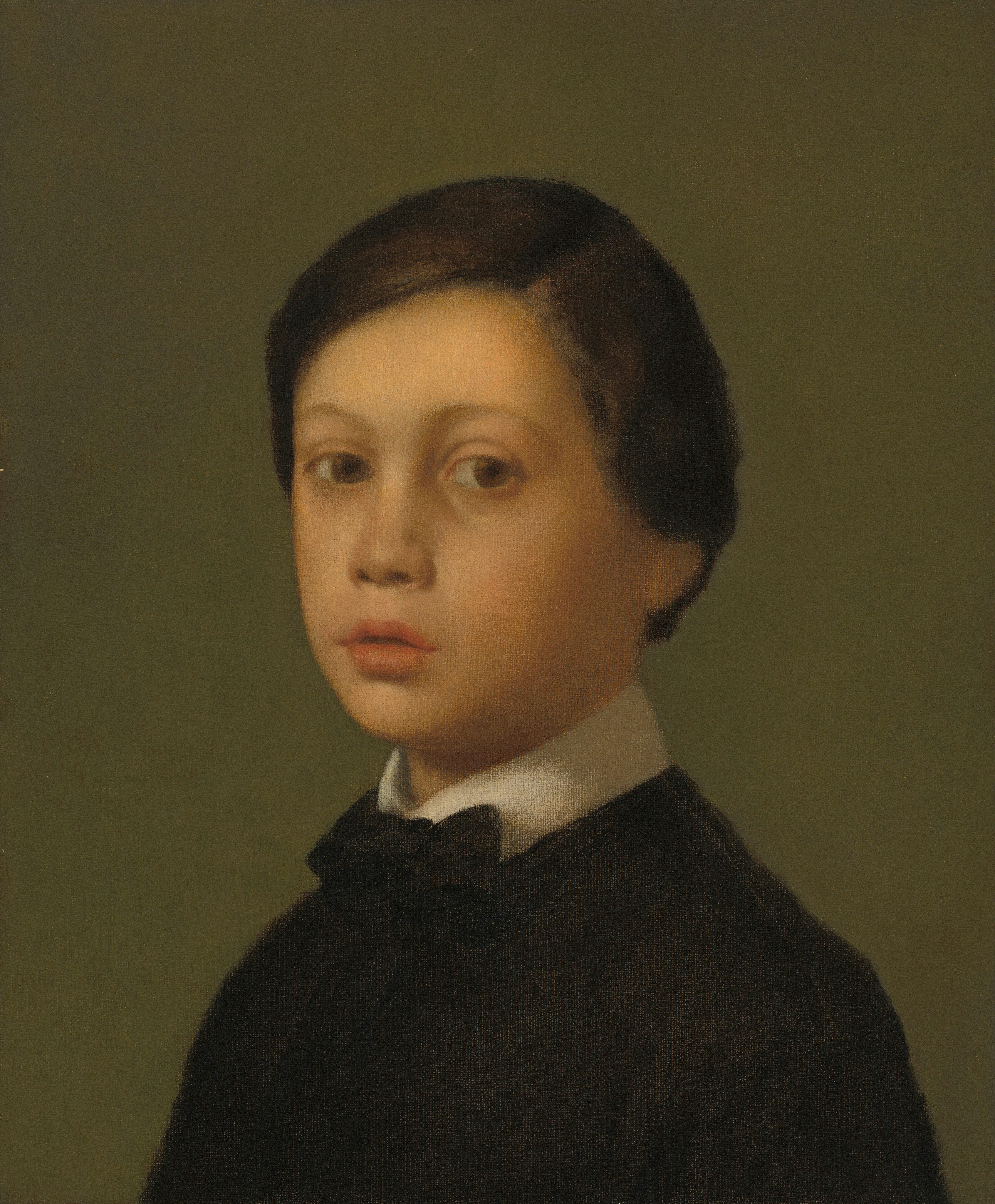 A young boy in formal attire looks forward.