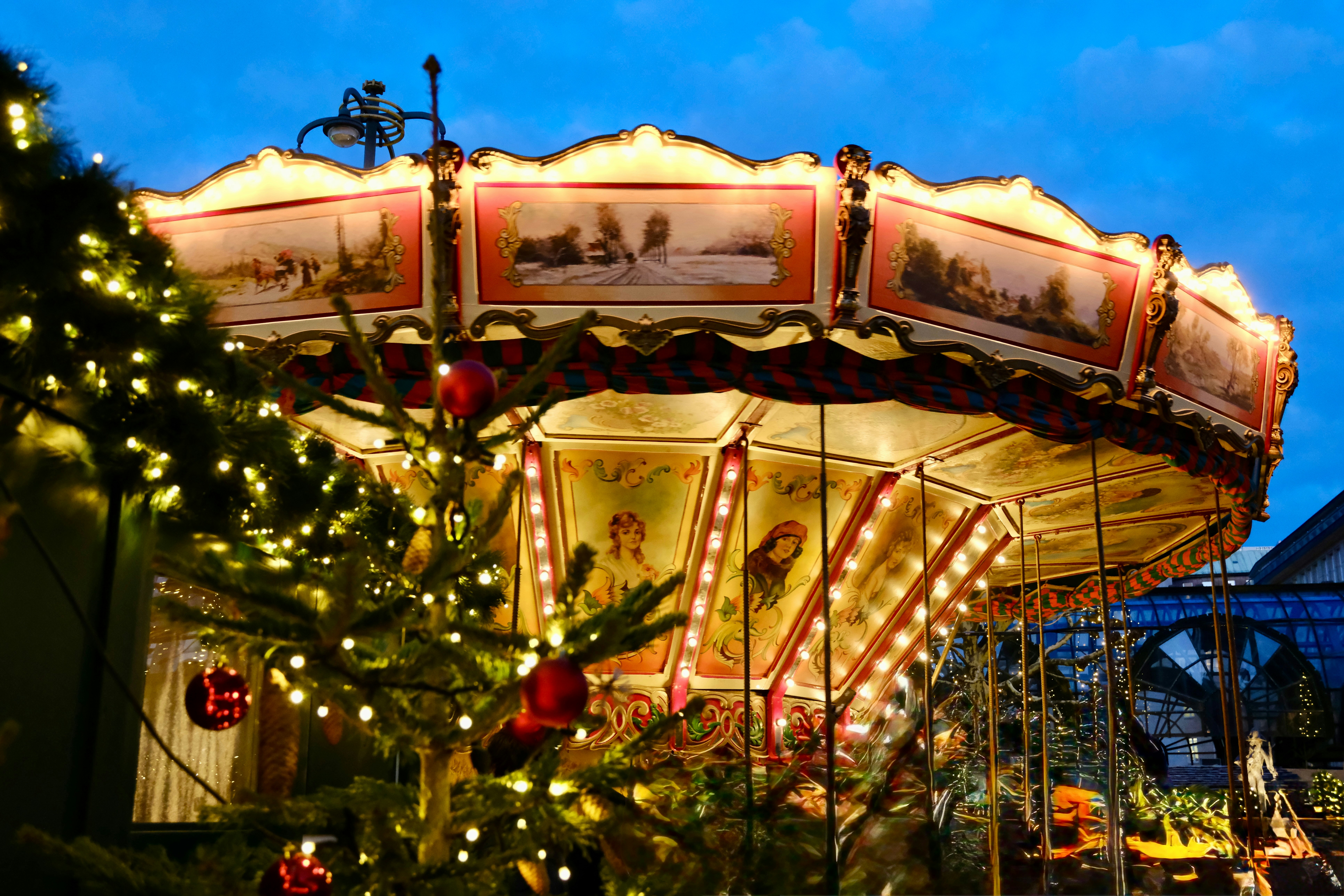 A brightly lit carousel at a festive market.