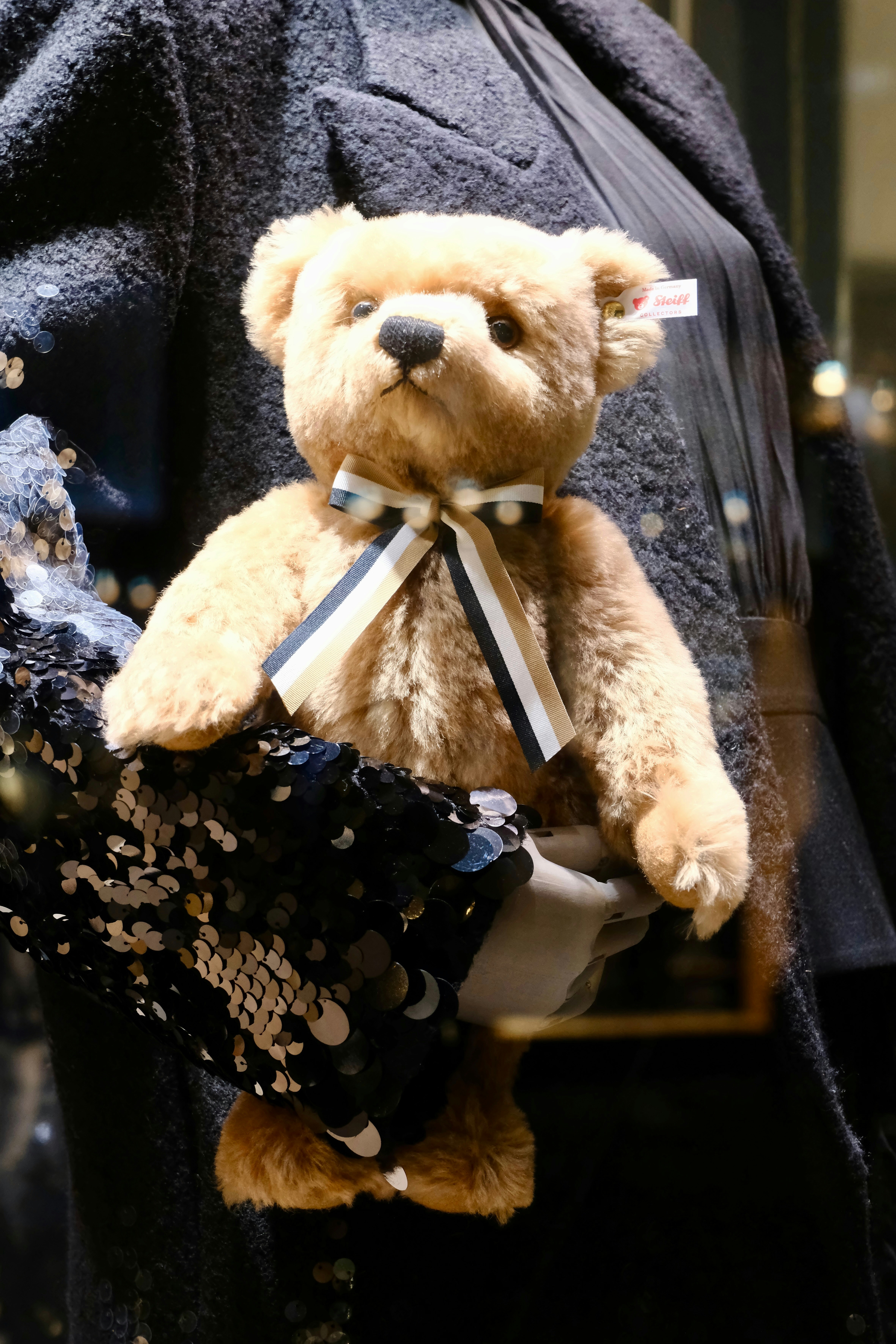 A fluffy teddy bear with a striped bow tie.