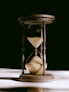 An antique hourglass with sand flowing