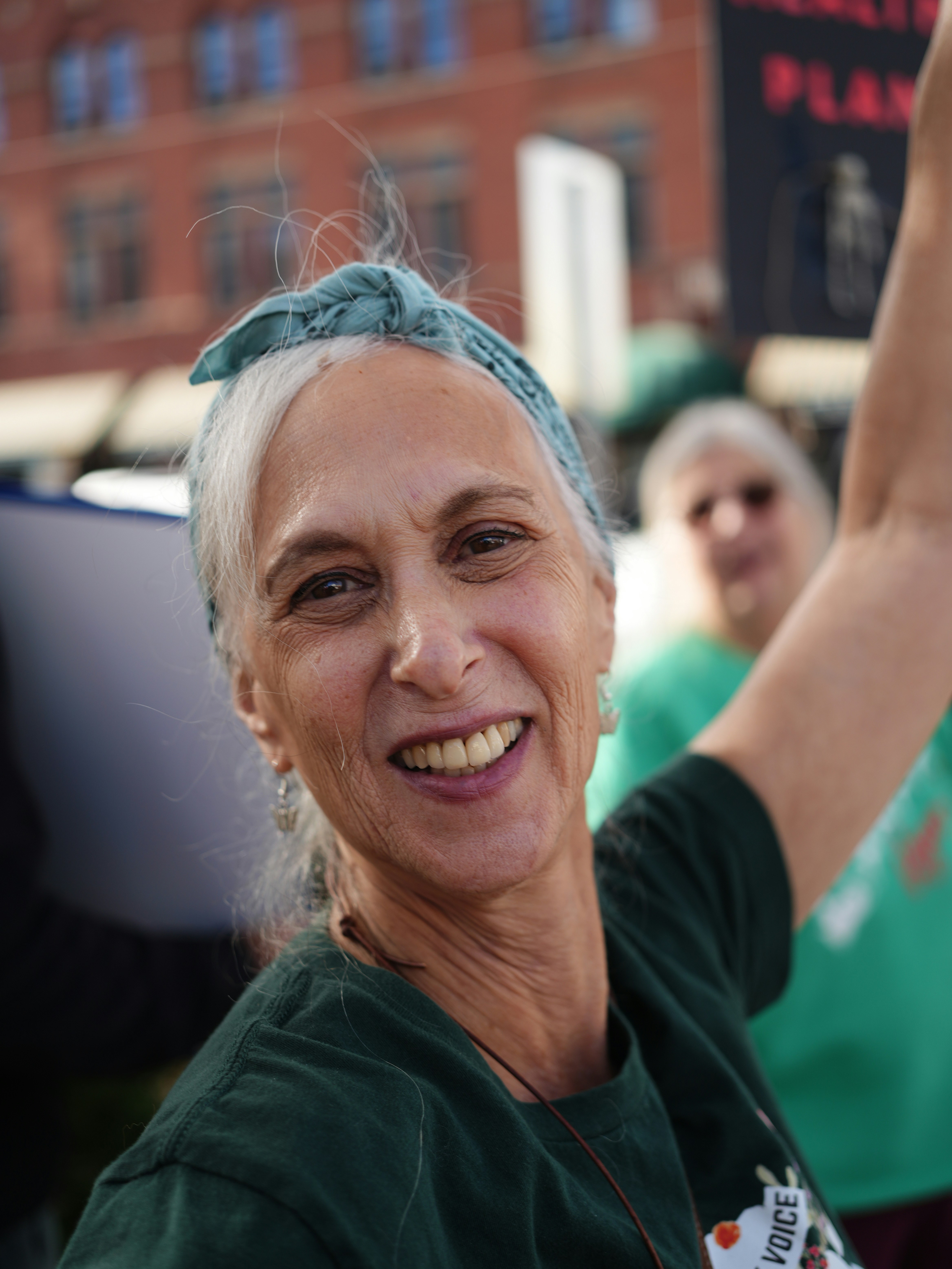 A smiling woman with a bandana in her hair.