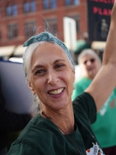 A smiling woman with a bandana in her hair.