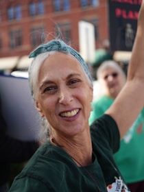 A smiling woman with a bandana in her hair.