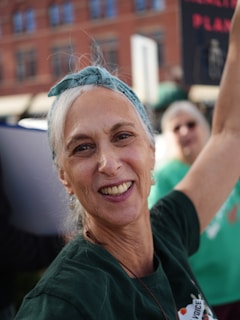 A smiling woman with a bandana in her hair.