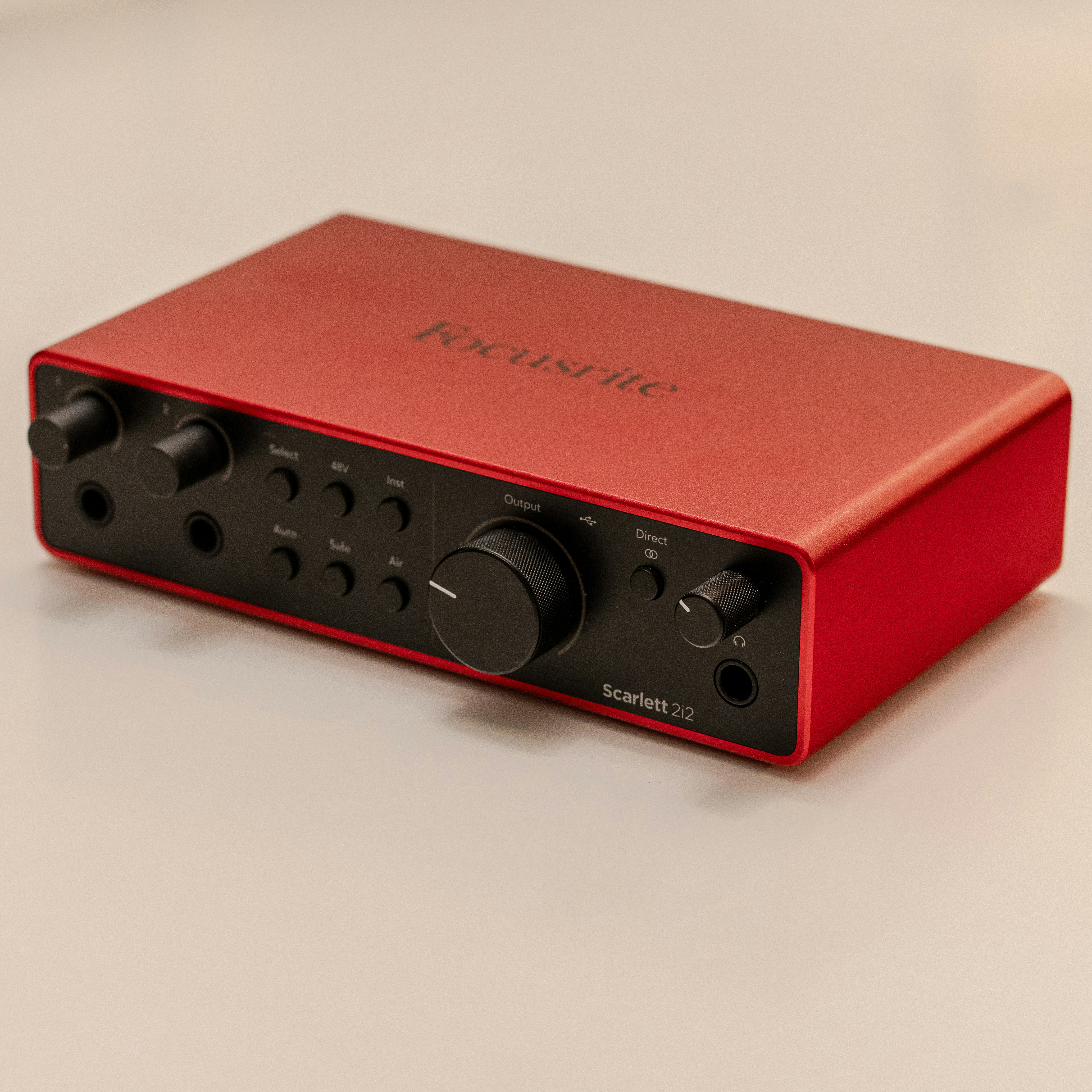 Red audio interface with black knobs and buttons