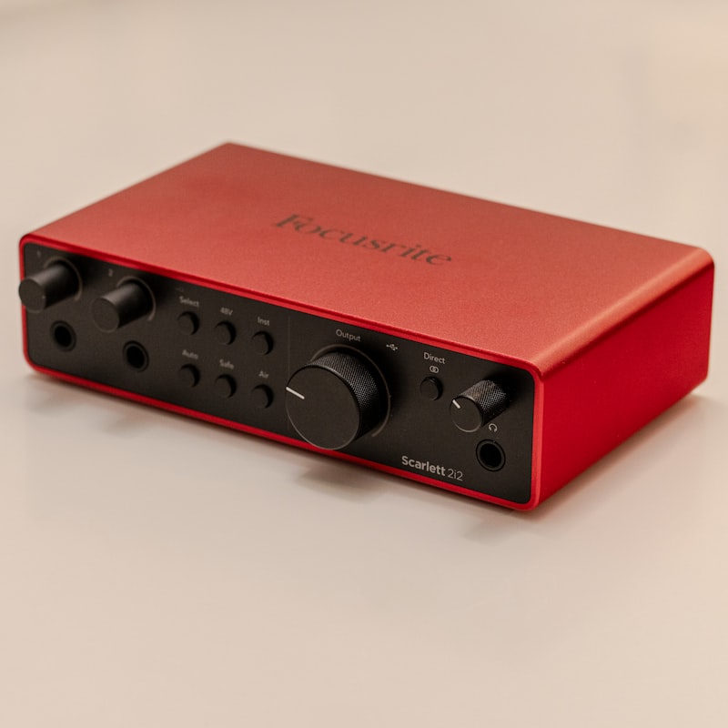 Red audio interface with controls on a desk
