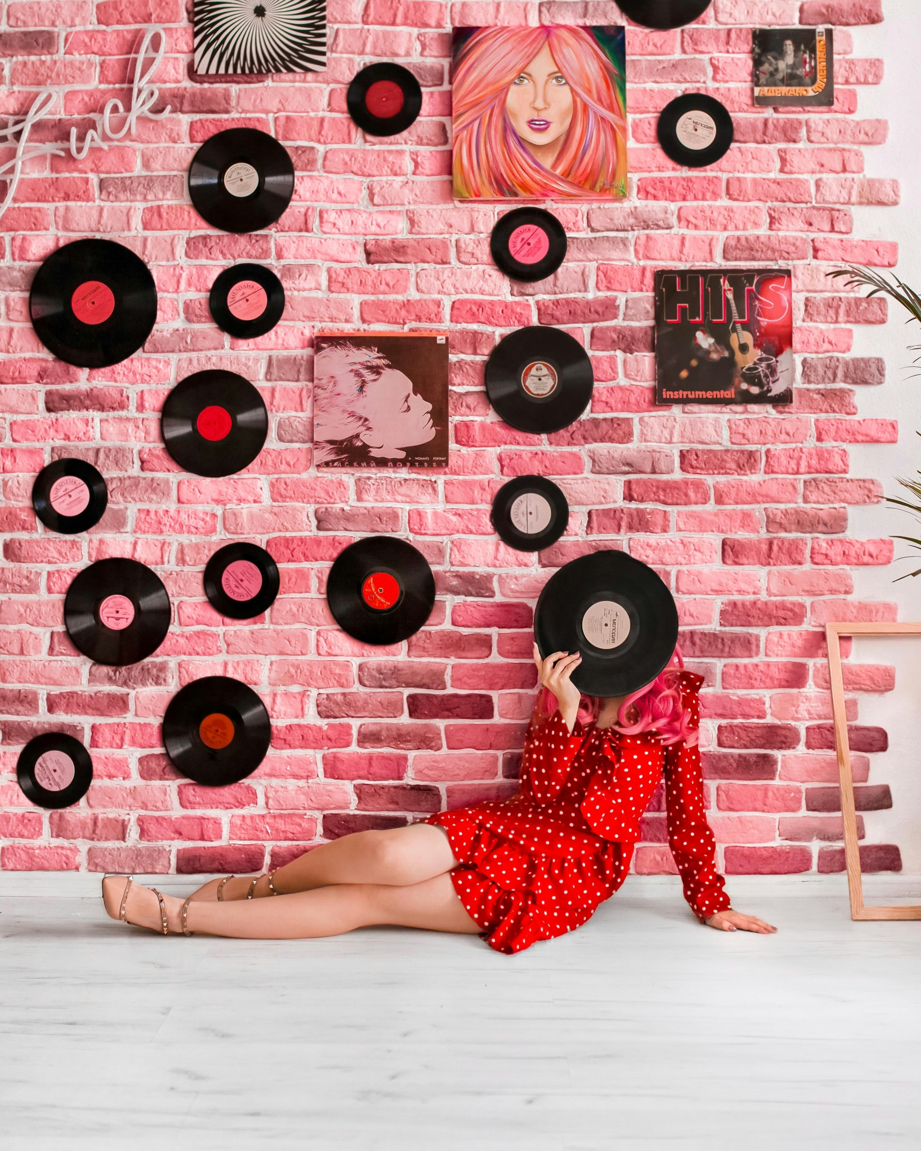 девушка в красном платье girl in red dress возле розовой кирпичной стены