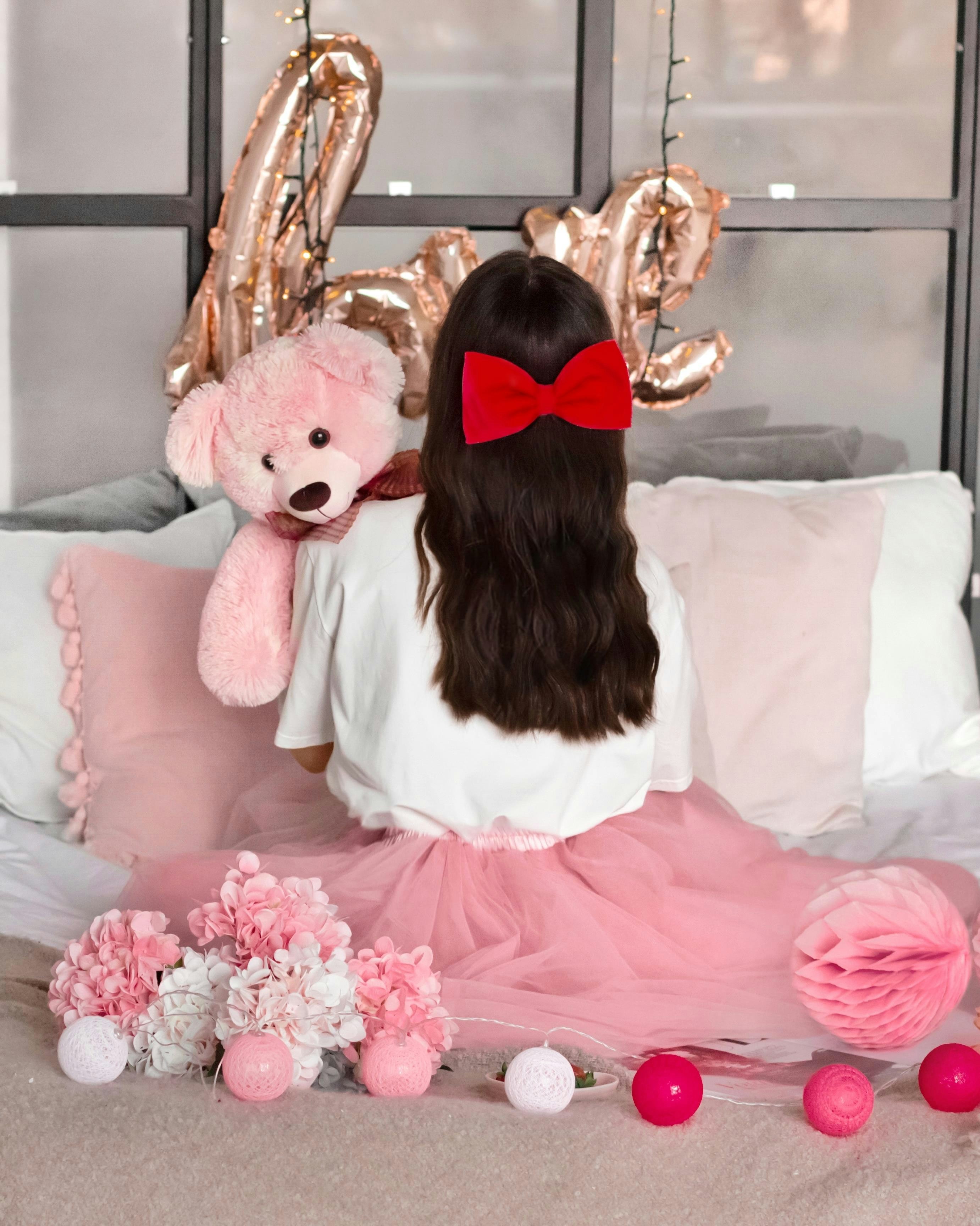 Girl with teddy bear and pink decorations