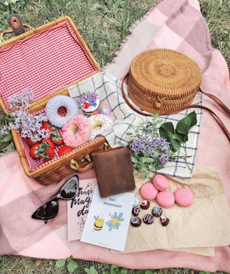 Picnic basket filled with donuts, strawberries, and macarons.
