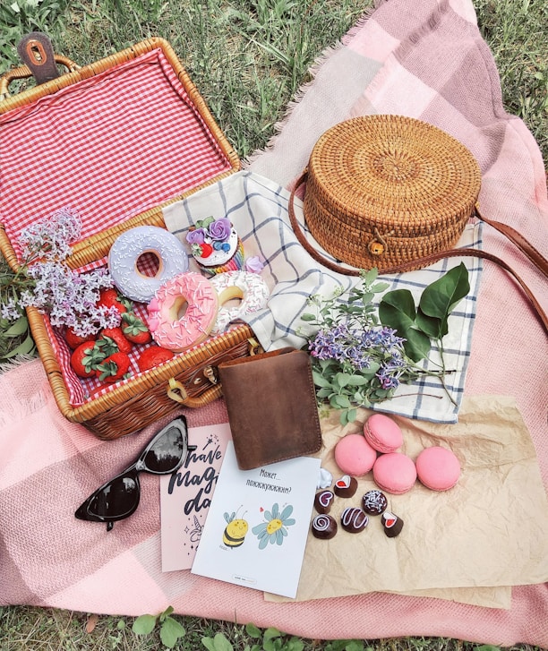 Picnic basket filled with donuts, strawberries, and macarons.