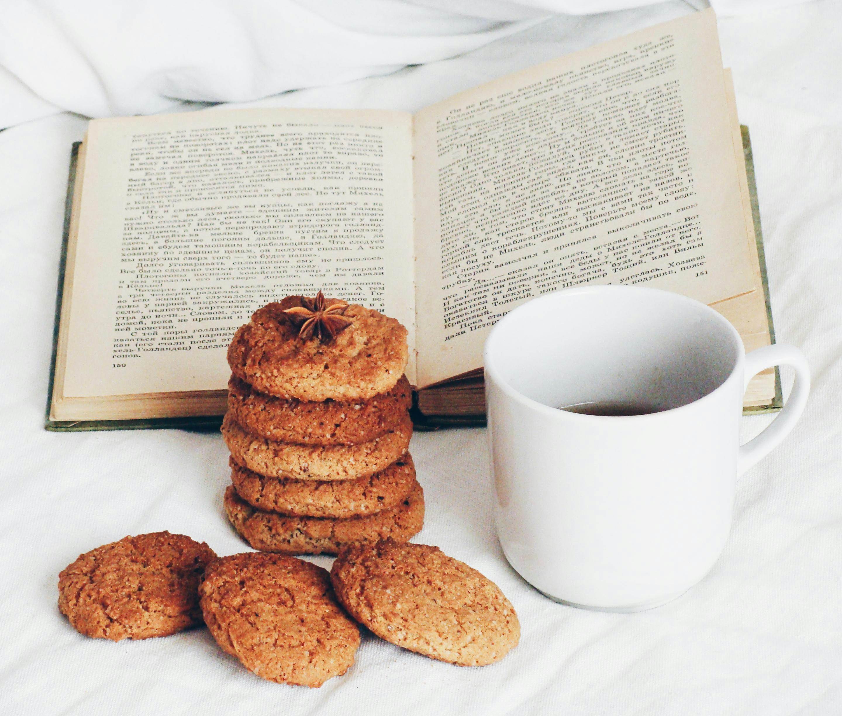Stack of cookies with coffee and open book.