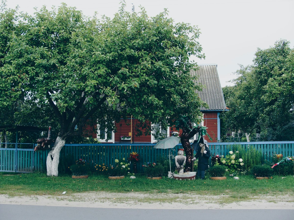 A red house with a blue fence and garden, illustrating a potential site for youth group community service projects.