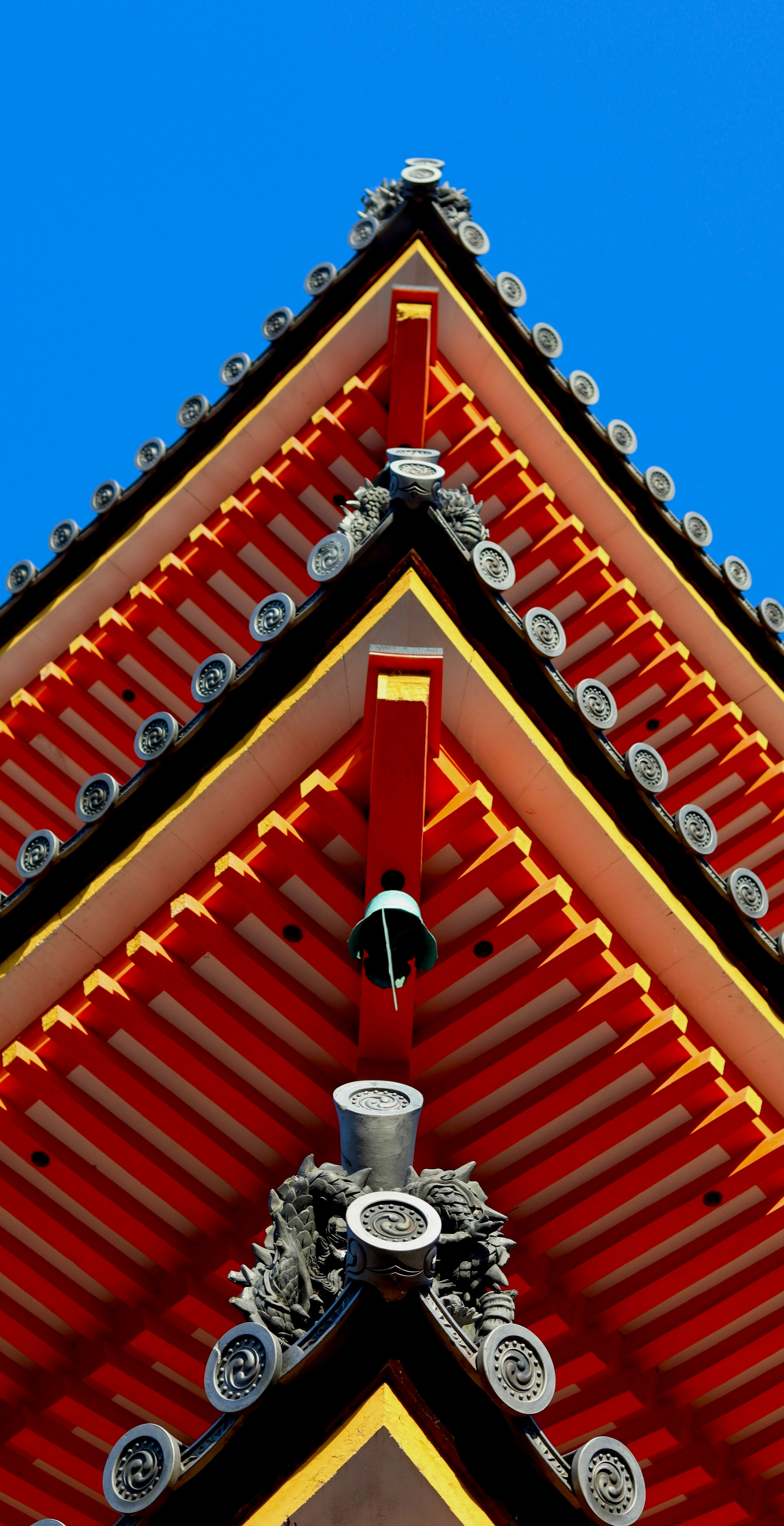 赤い軒と鐘を持つ伝統的な日本の寺院の屋根