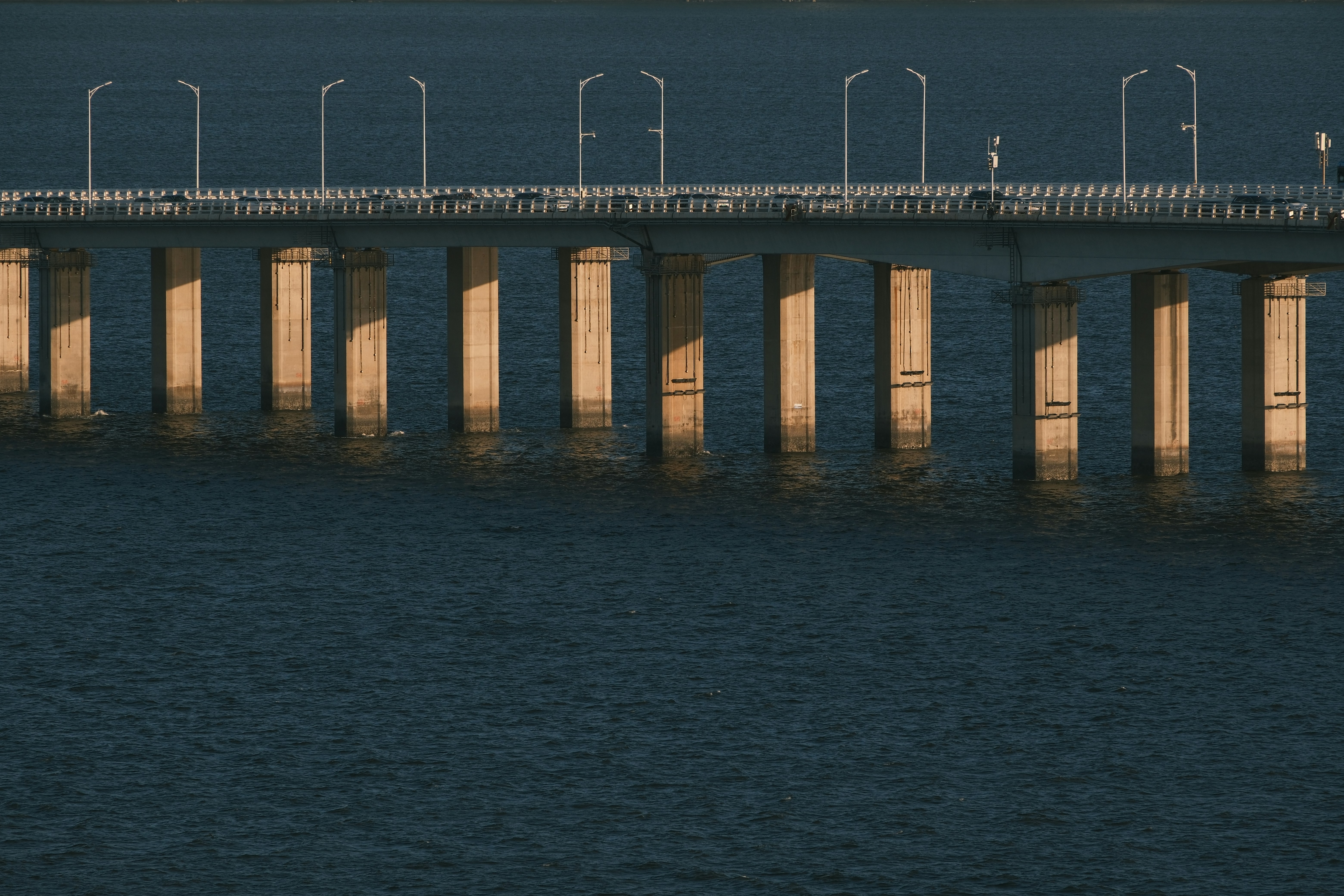 Concrete bridge with lights over dark water