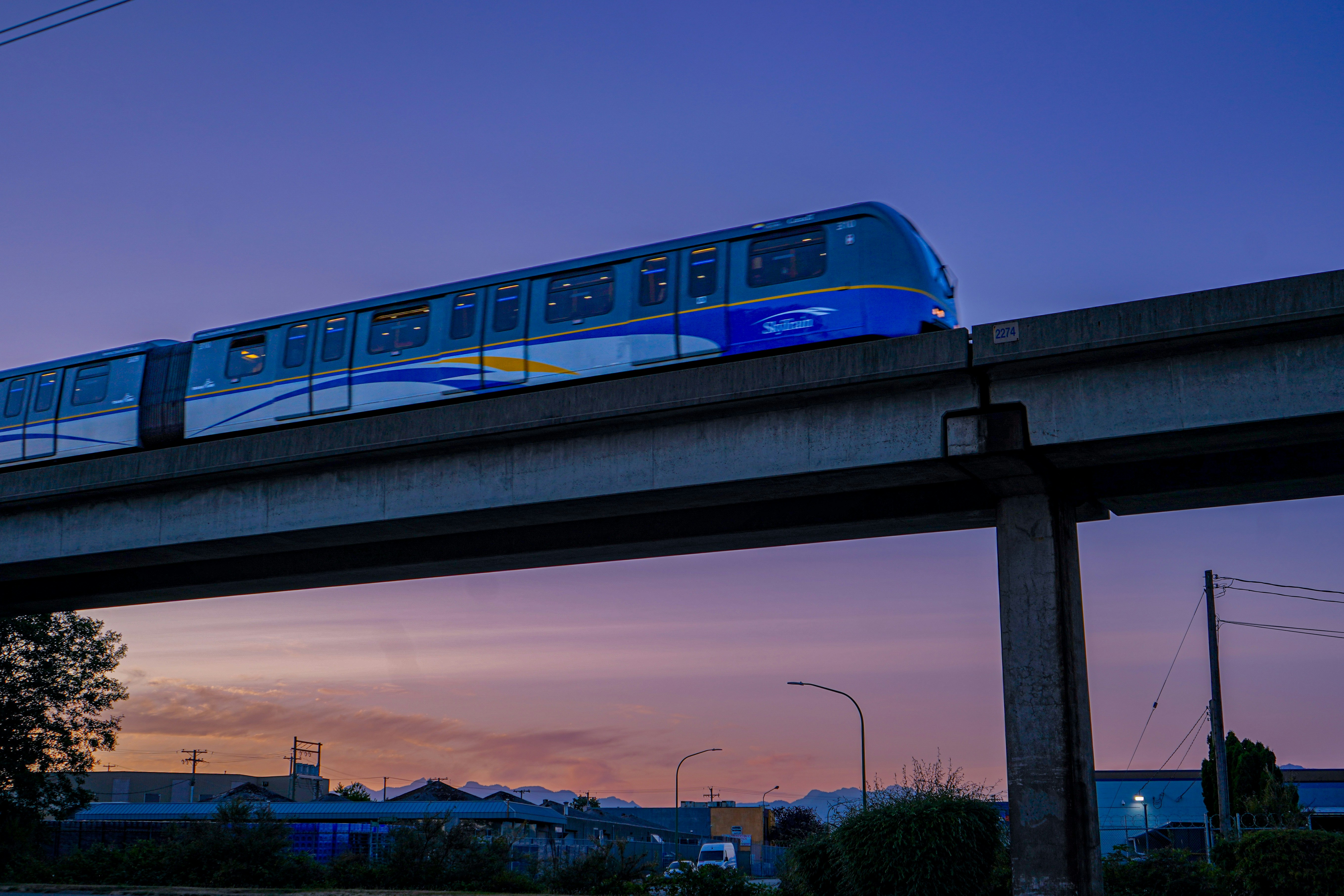 Der Monorail-Zug fährt in der Dämmerung auf Hochbahnschienen.