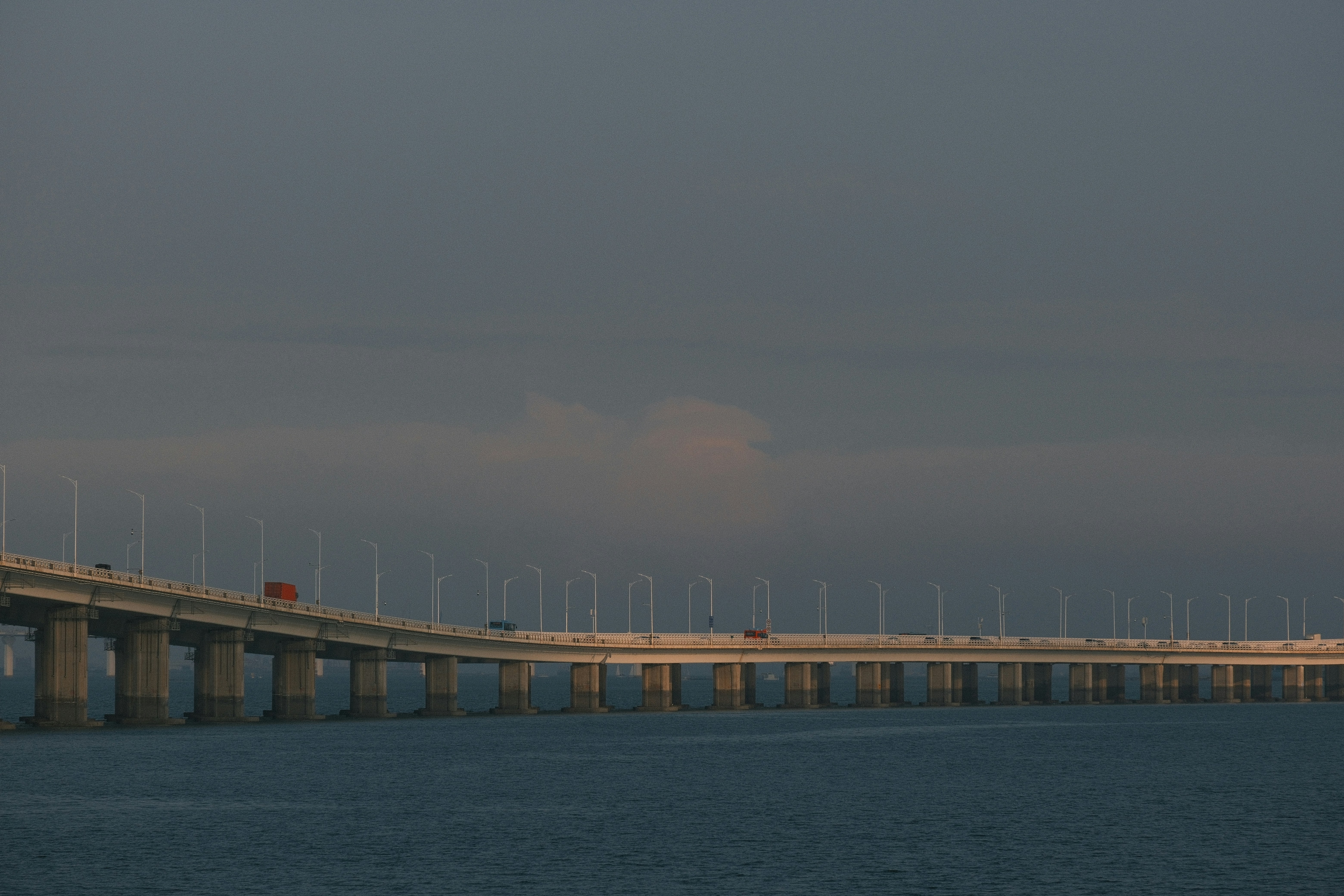 Long bridge over water with streetlights