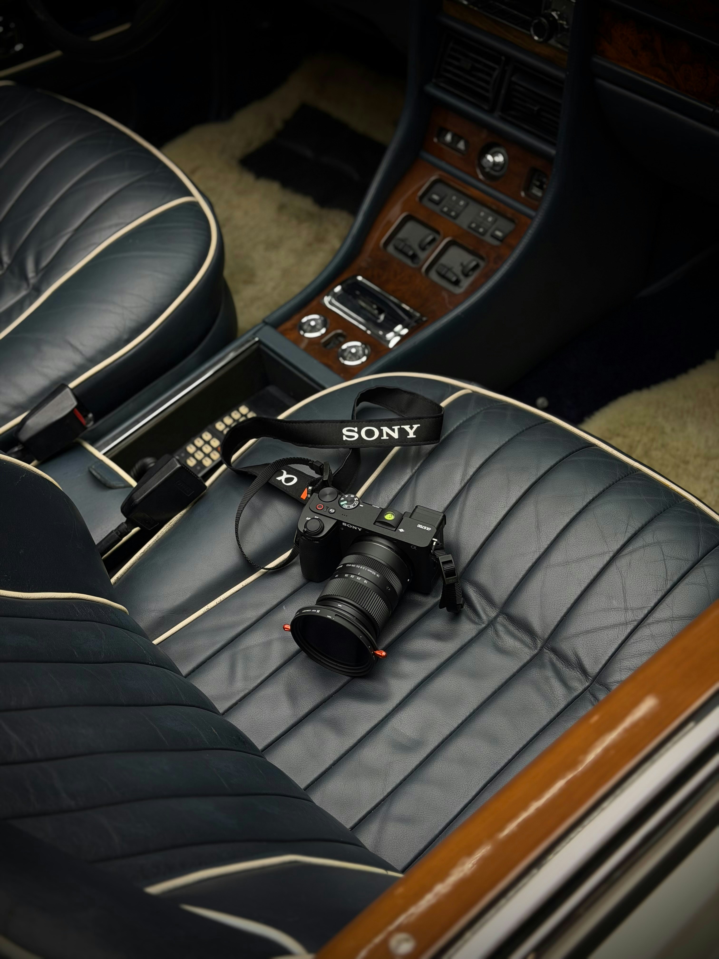 A sony camera rests on vintage car seats.