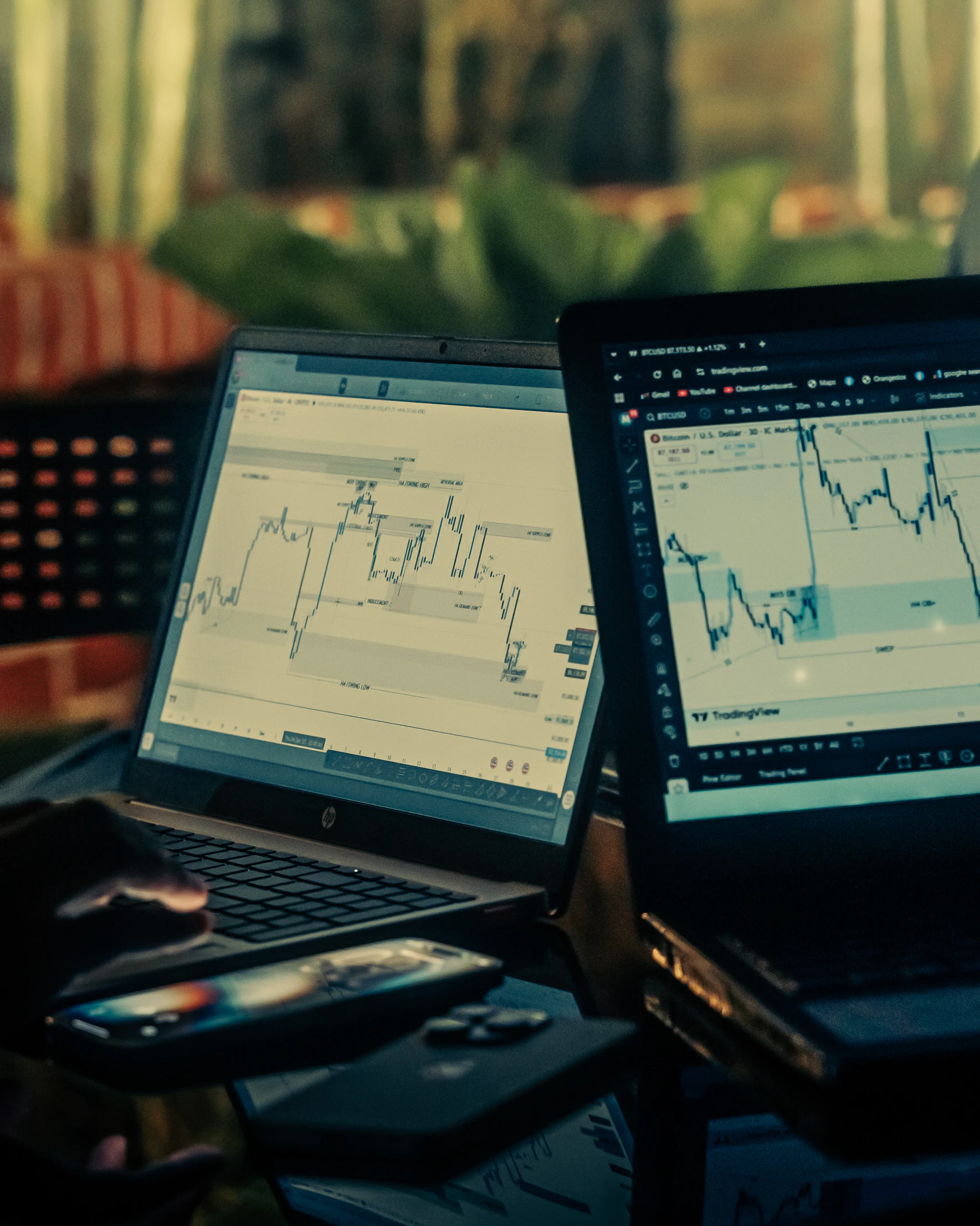 Trading charts displayed across laptop screens