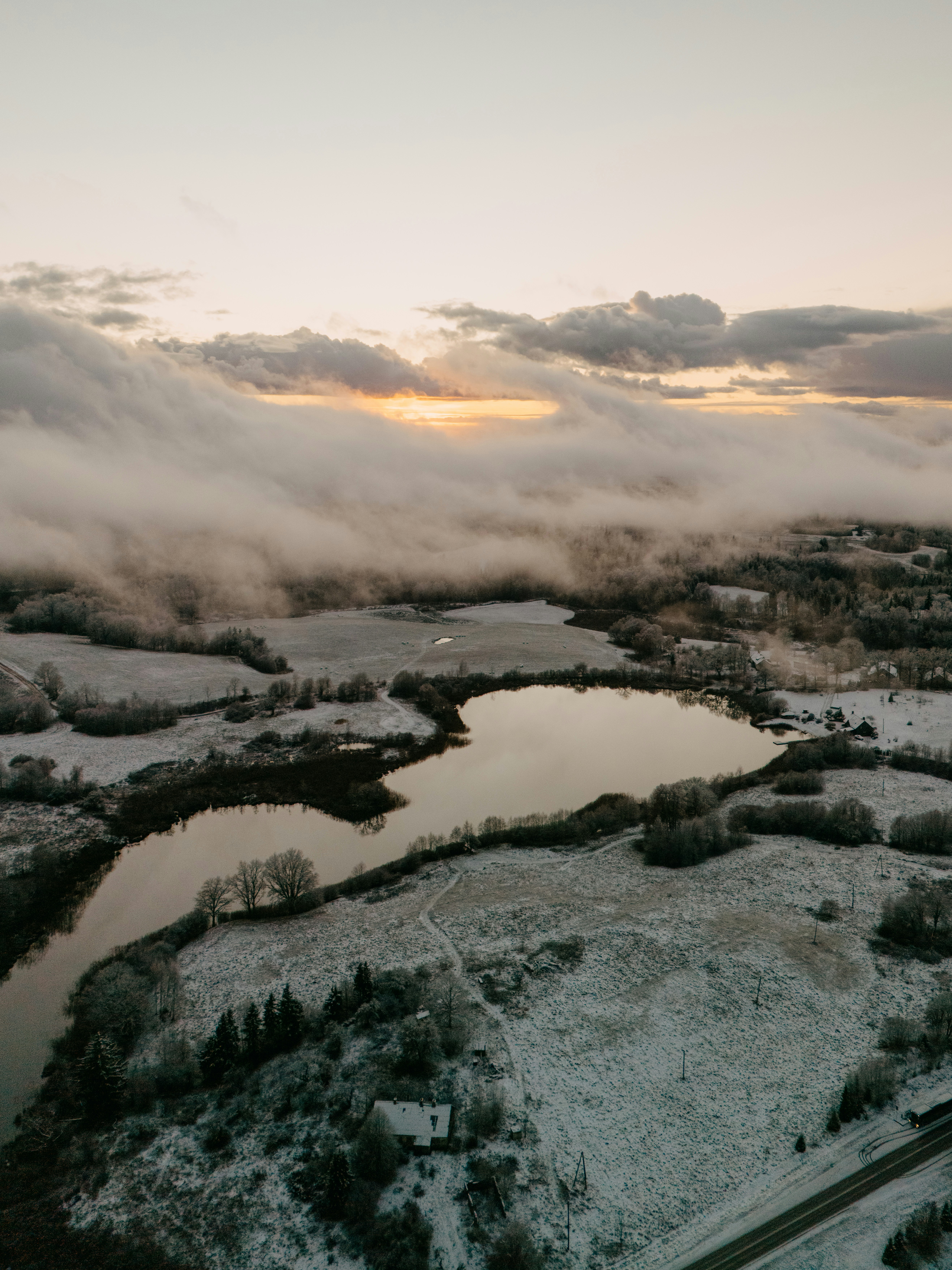Snowy landscape with a lake at sunset