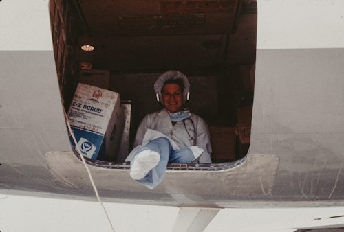 A medical officer with health supplies aboard a cargo aircraft