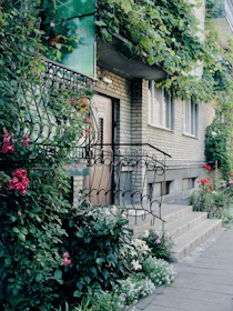 Entrance to a building with flowering plants and vines.